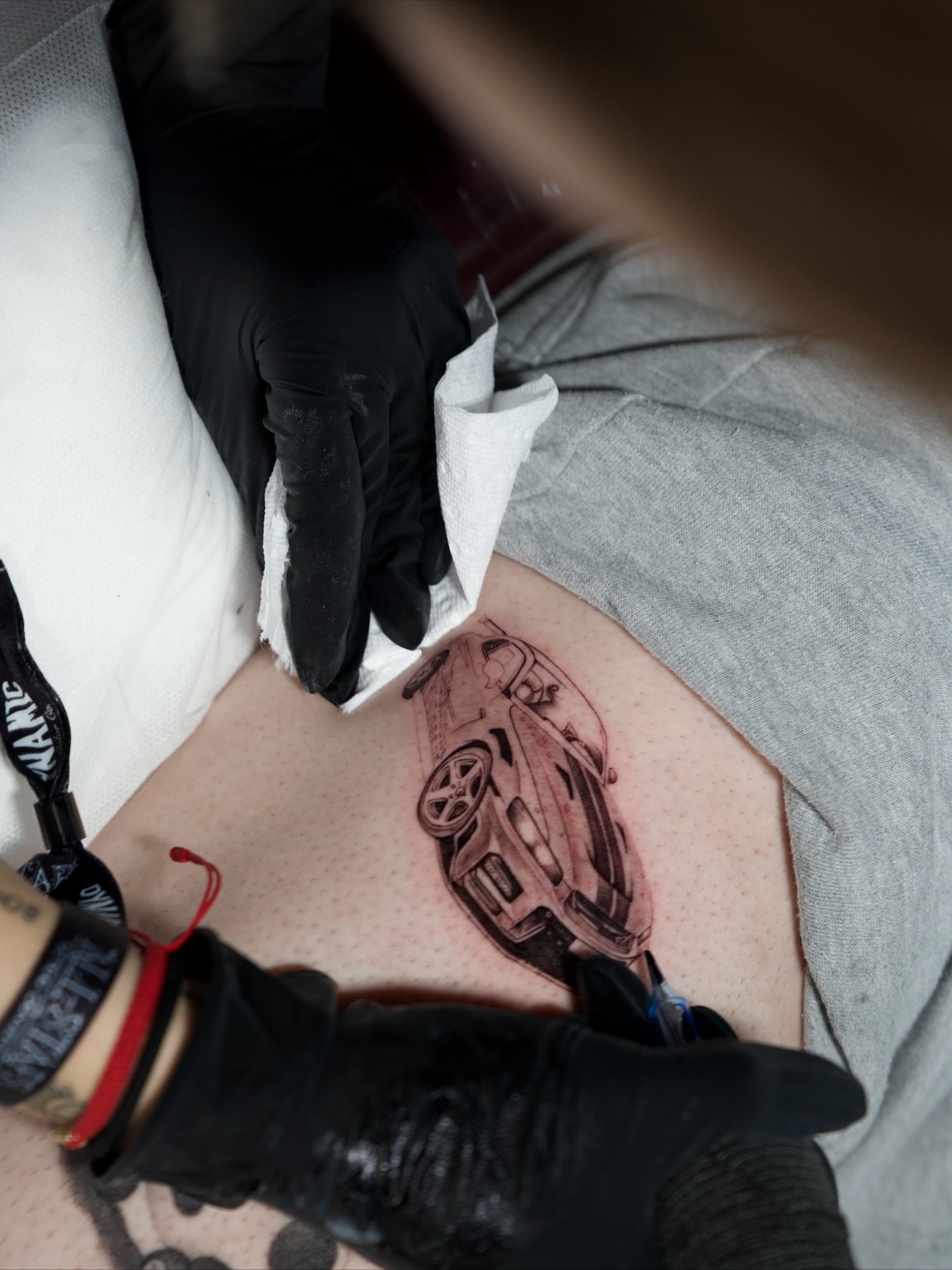 Car realism tattoo on the thigh by Sophia Delfino