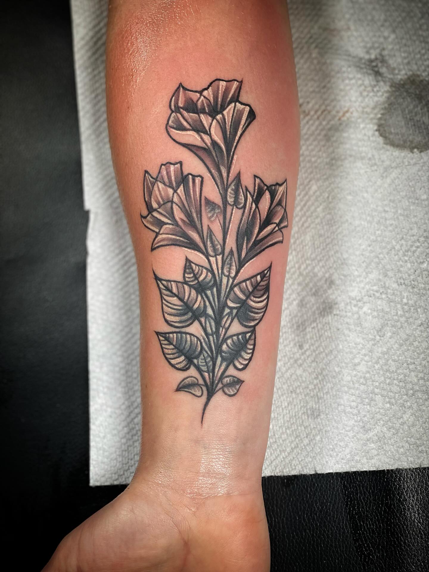 Flower black and grey tattoo on the forearm by Chris Klee