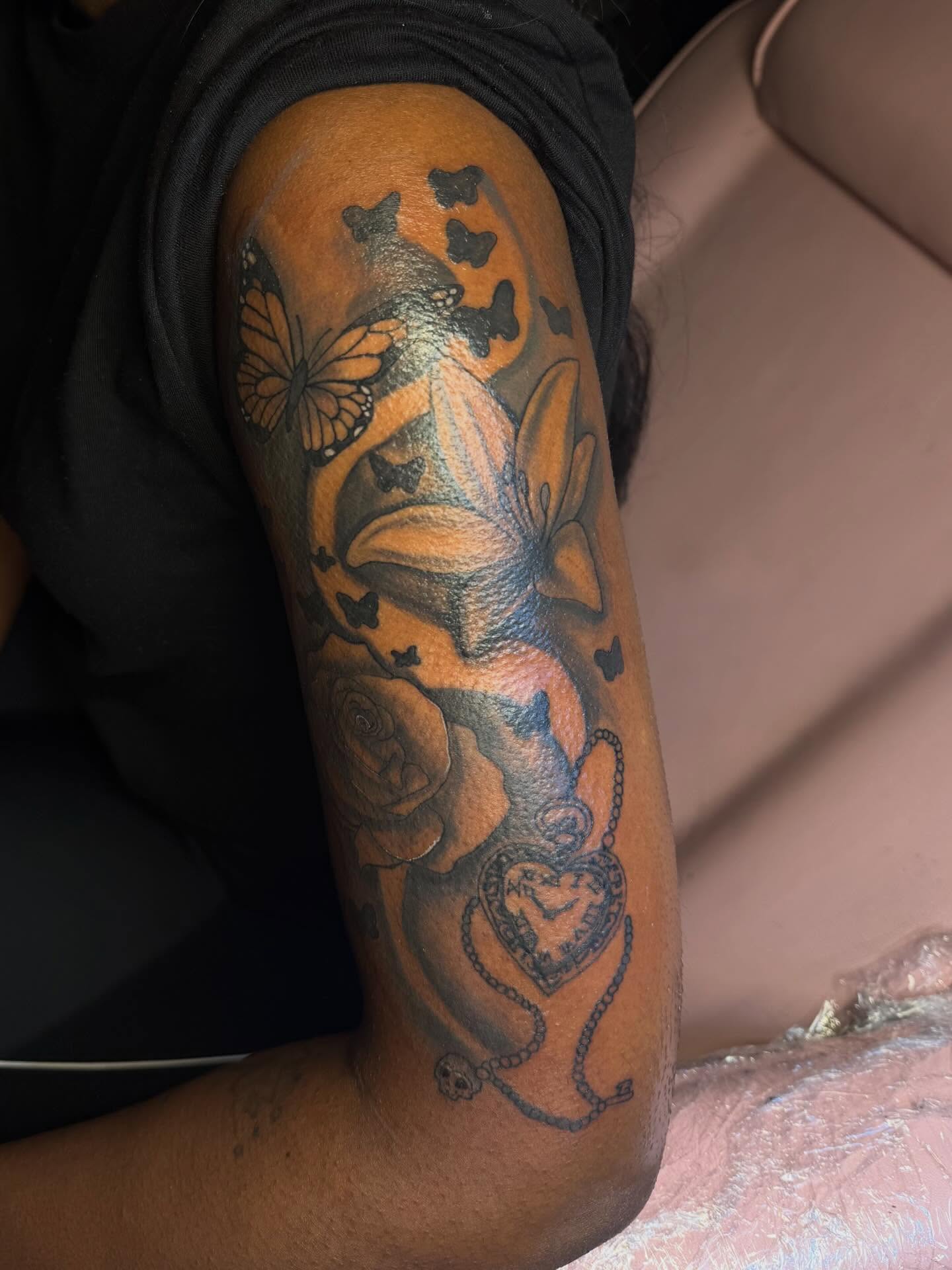 Butterfly and flower black and grey tattoo on the forearm by Tatted By Layy