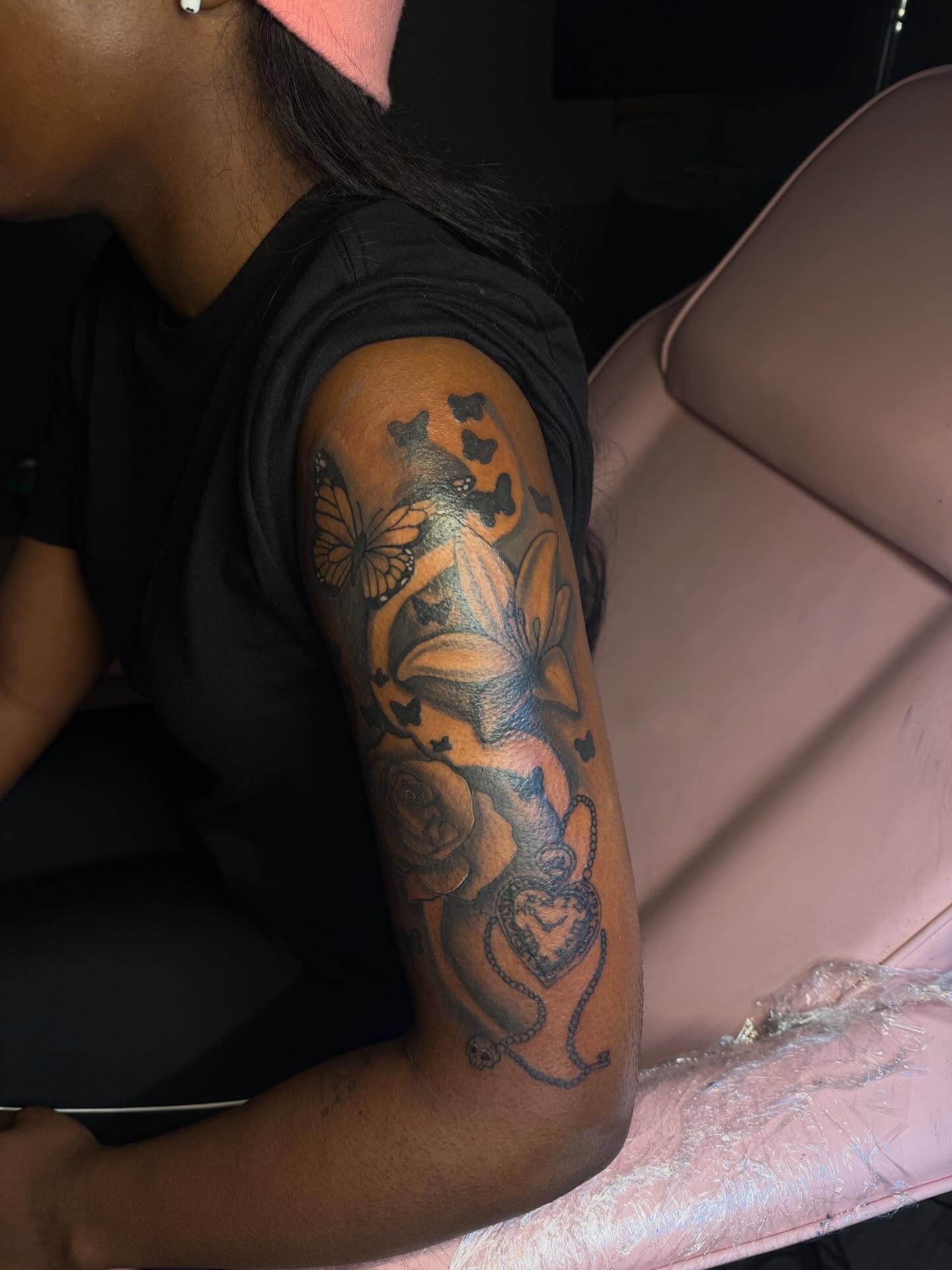 Floral and butterfly black and grey tattoo on the forearm by Tatted By Layy