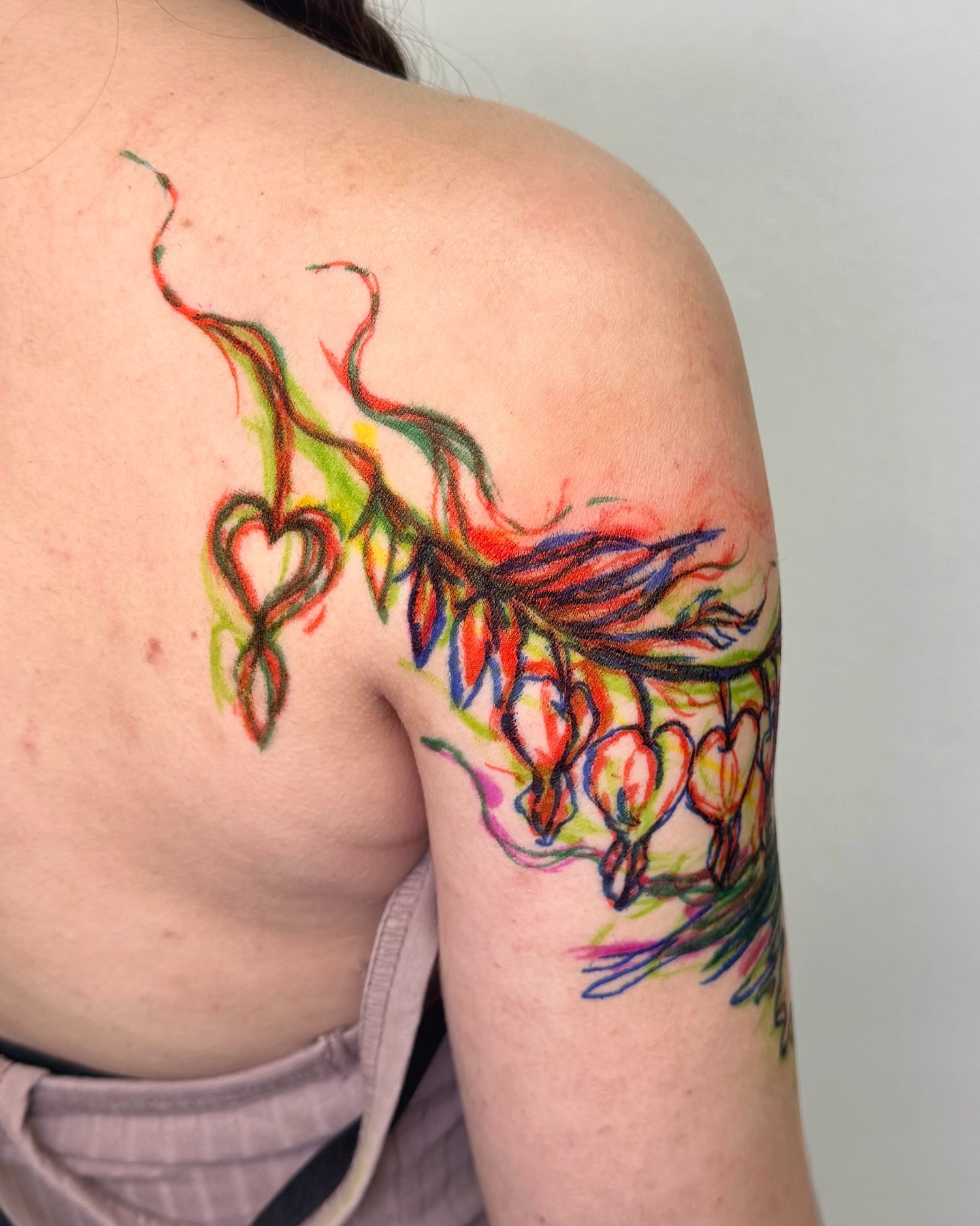 Flower and heart watercolor tattoo on the shoulder by Mystikal Blue Casares