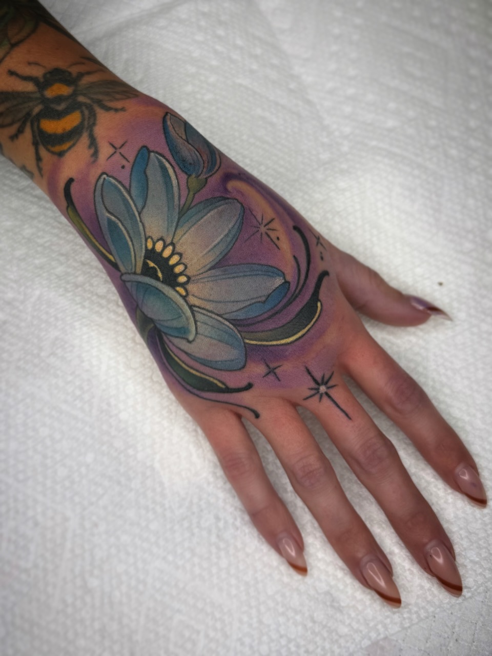 Flower and bee American traditional tattoo on the hand by Melis Fusco