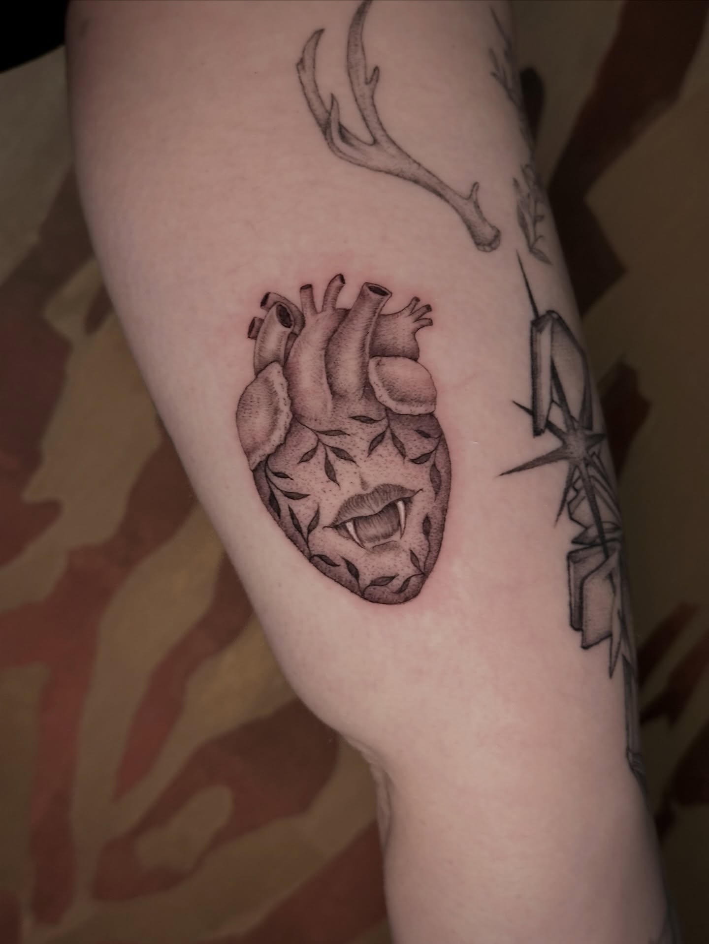 Heart with vampire fangs realism tattoo on the forearm by Carmen Figueroa, New York, New York