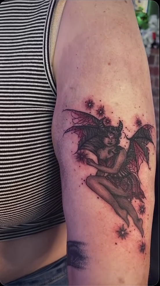 A winged demoness with stars realism tattoo on the forearm by Nikki Ward