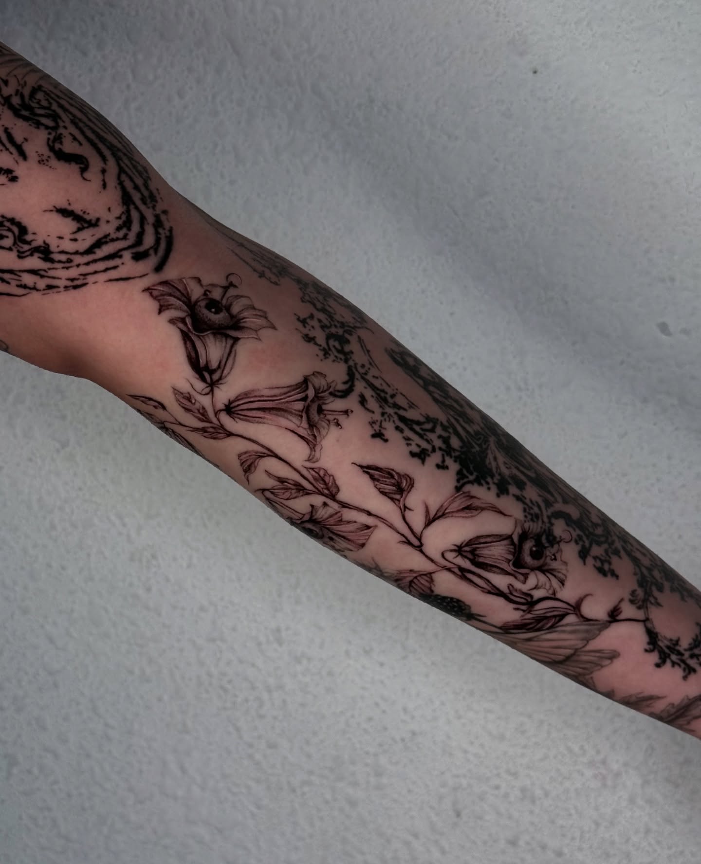 Floral arrangement black and grey tattoo on the forearm by josselyn ☪︎