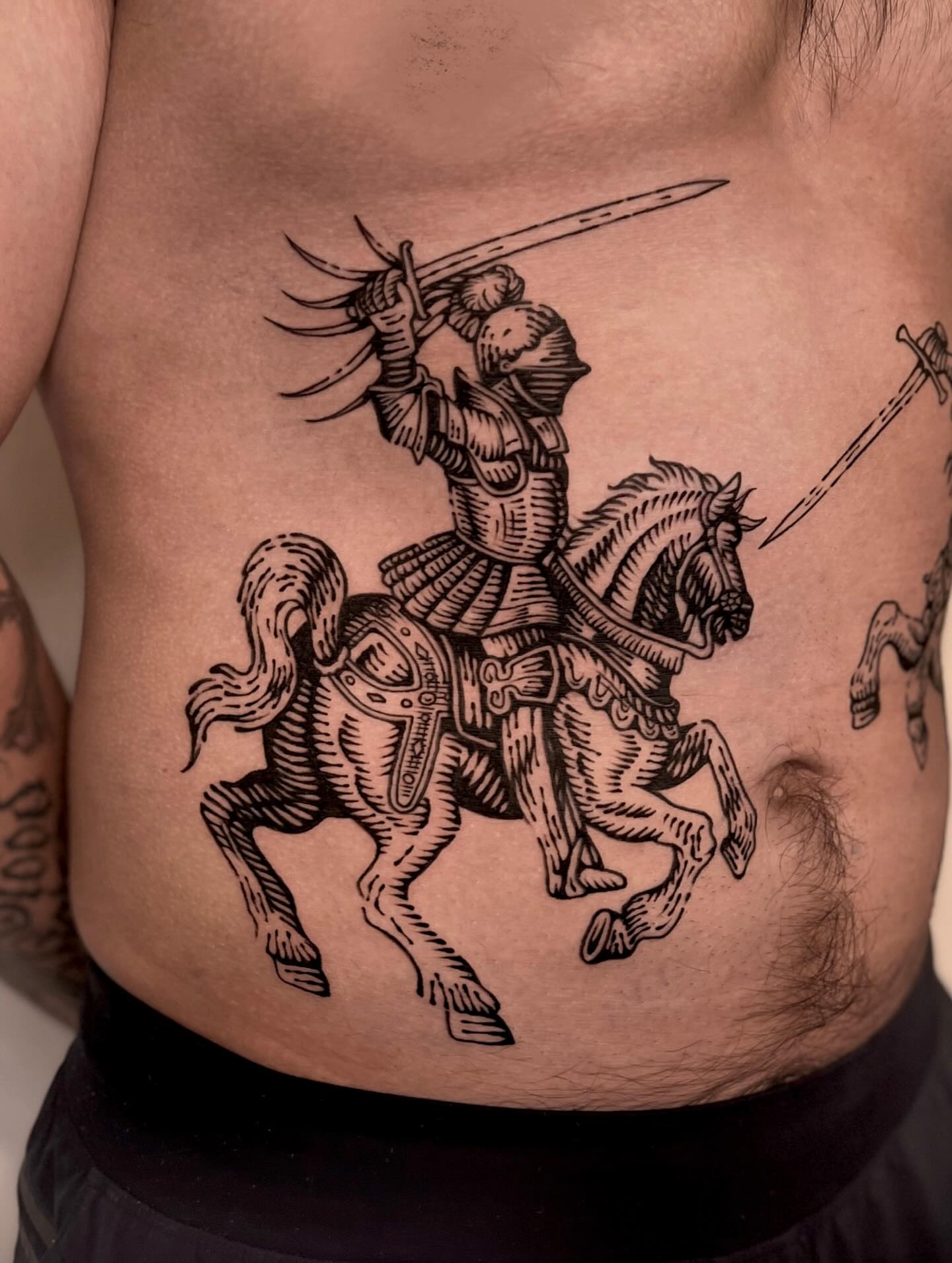 Knight on horseback black and grey tattoo on the chest by Wonny