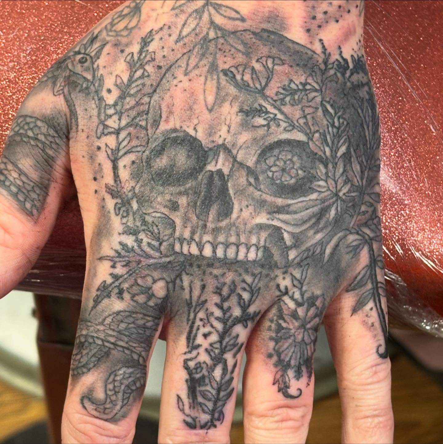 Skull and floral dotwork tattoo on the hand by Shane Montie, Killeen, Texas