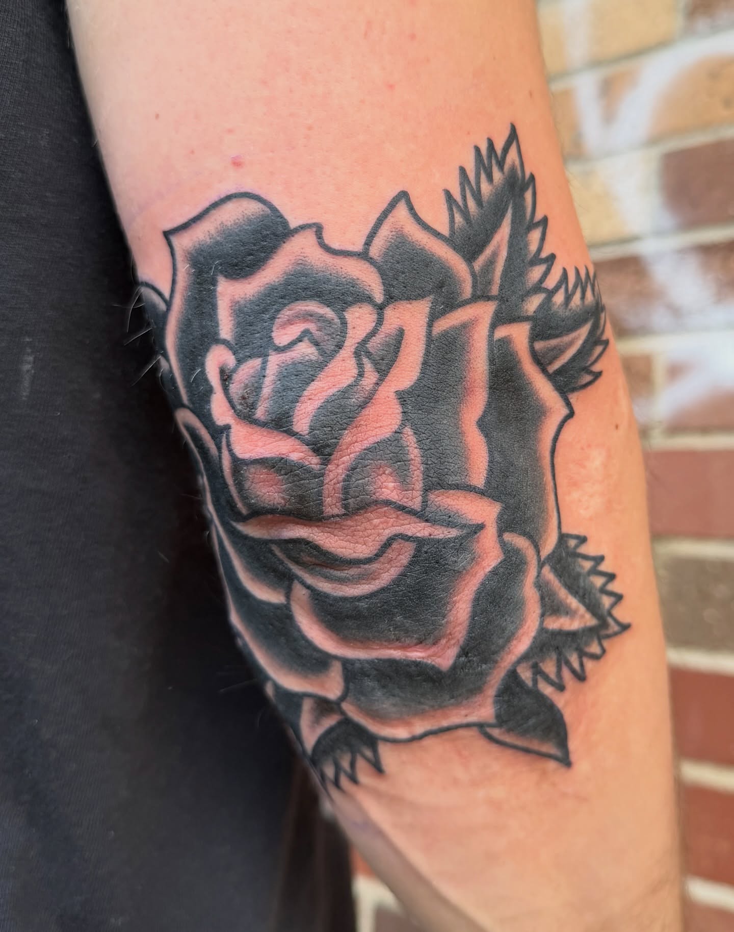 Rose black and grey tattoo on the forearm by Nick Judkins Tattoo