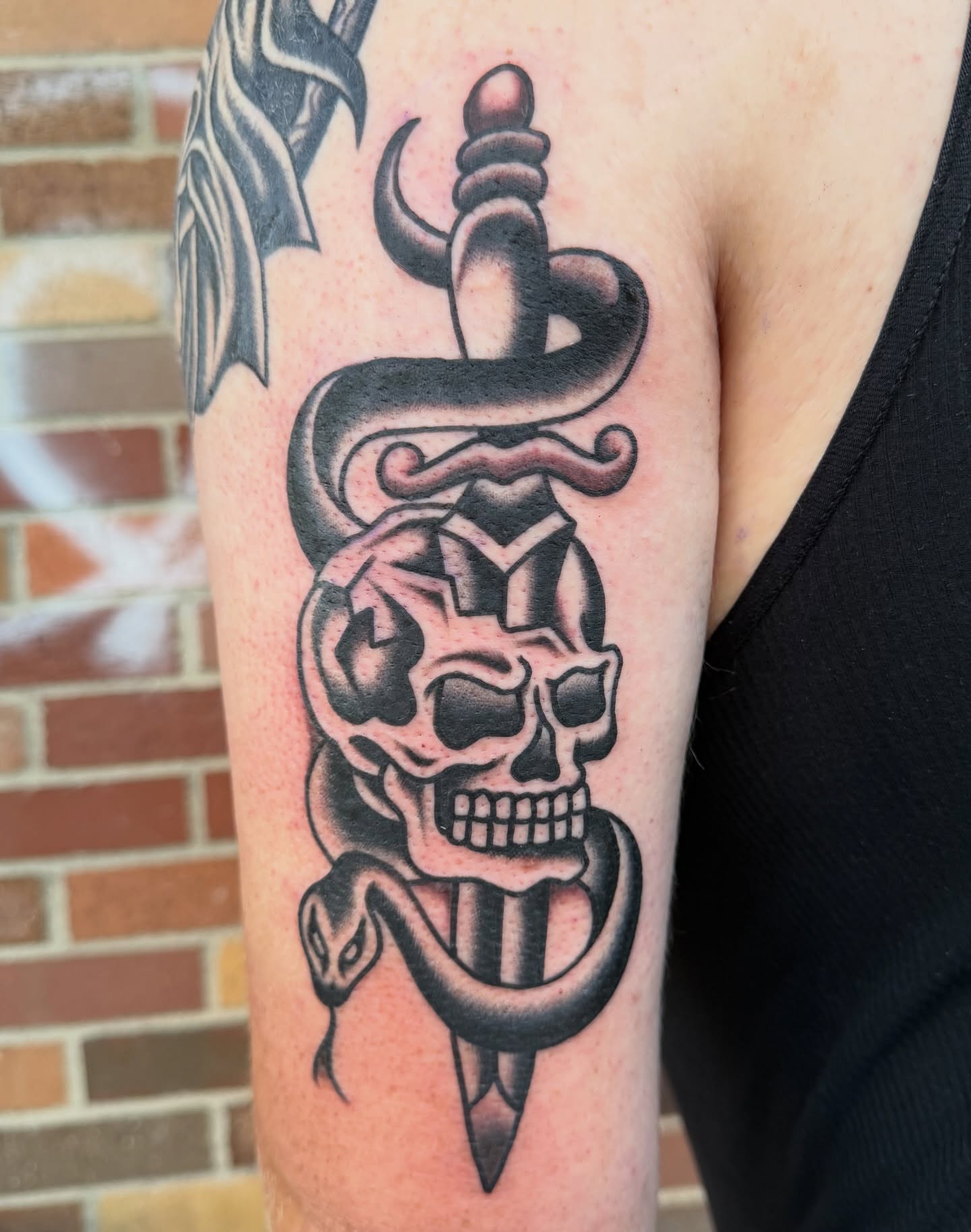 Skull and snake American traditional tattoo on the forearm by Nick Judkins Tattoo