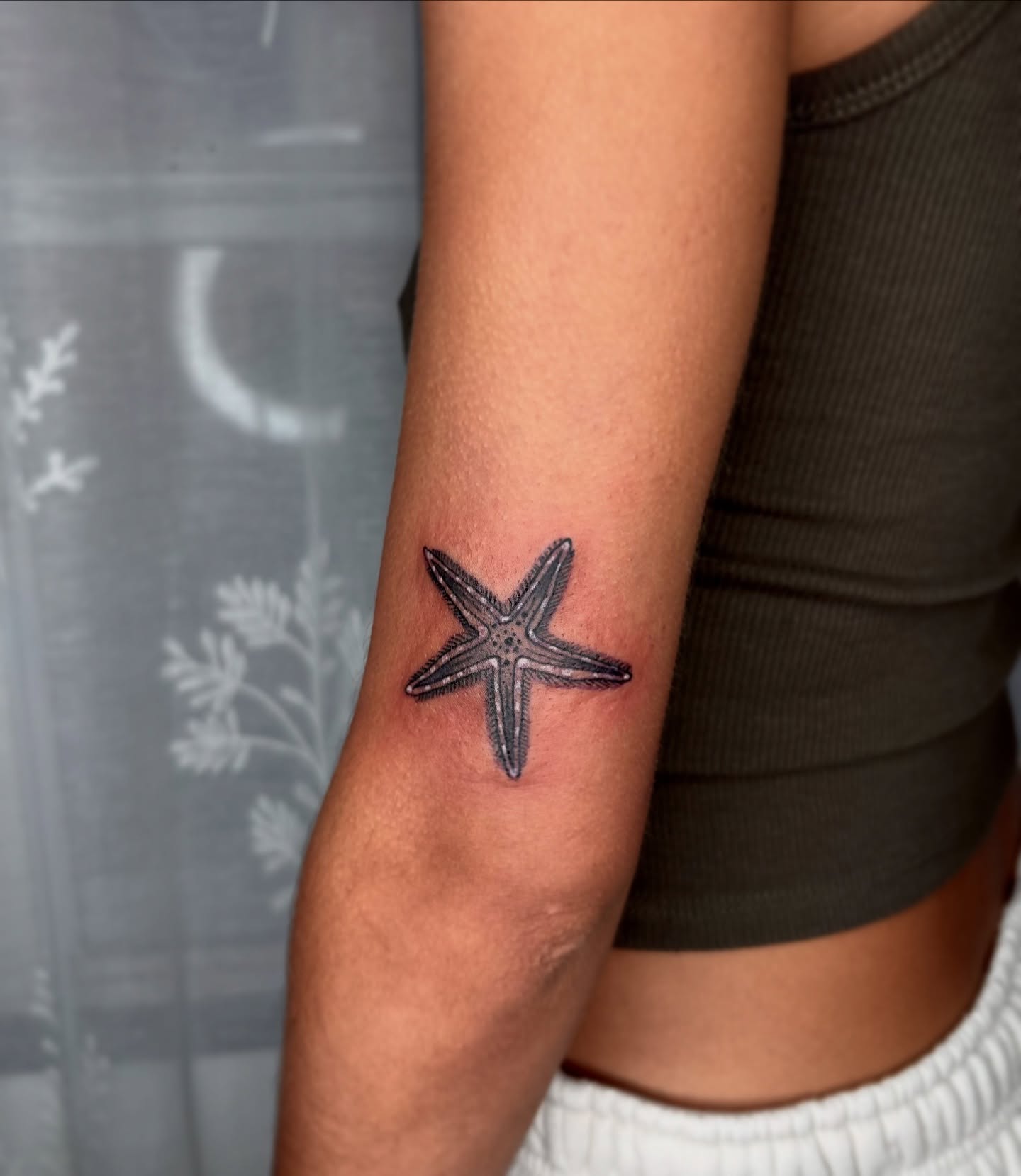 Starfish black and grey tattoo on the forearm by destiney rose