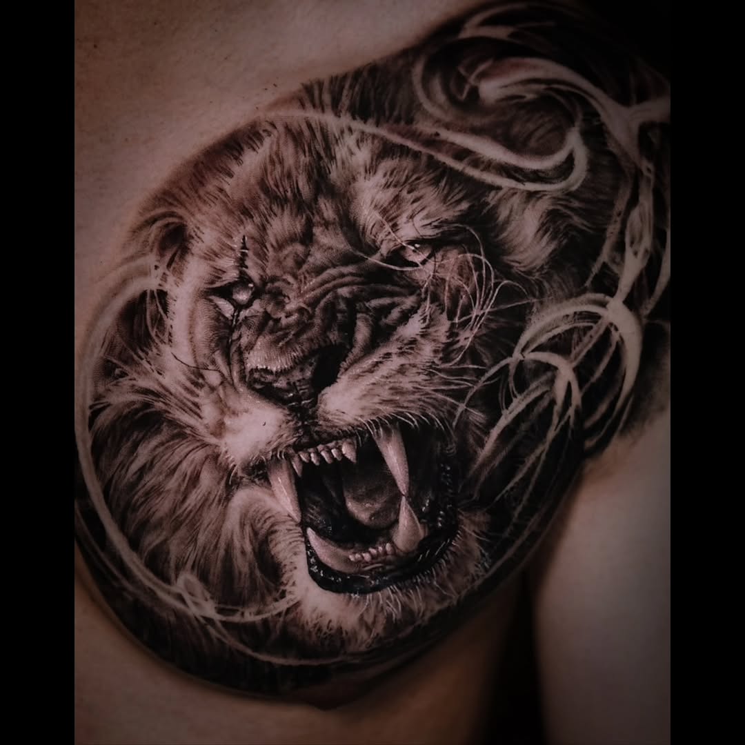Roaring lion face realism tattoo on the chest by Pitasso tattoo black and grey