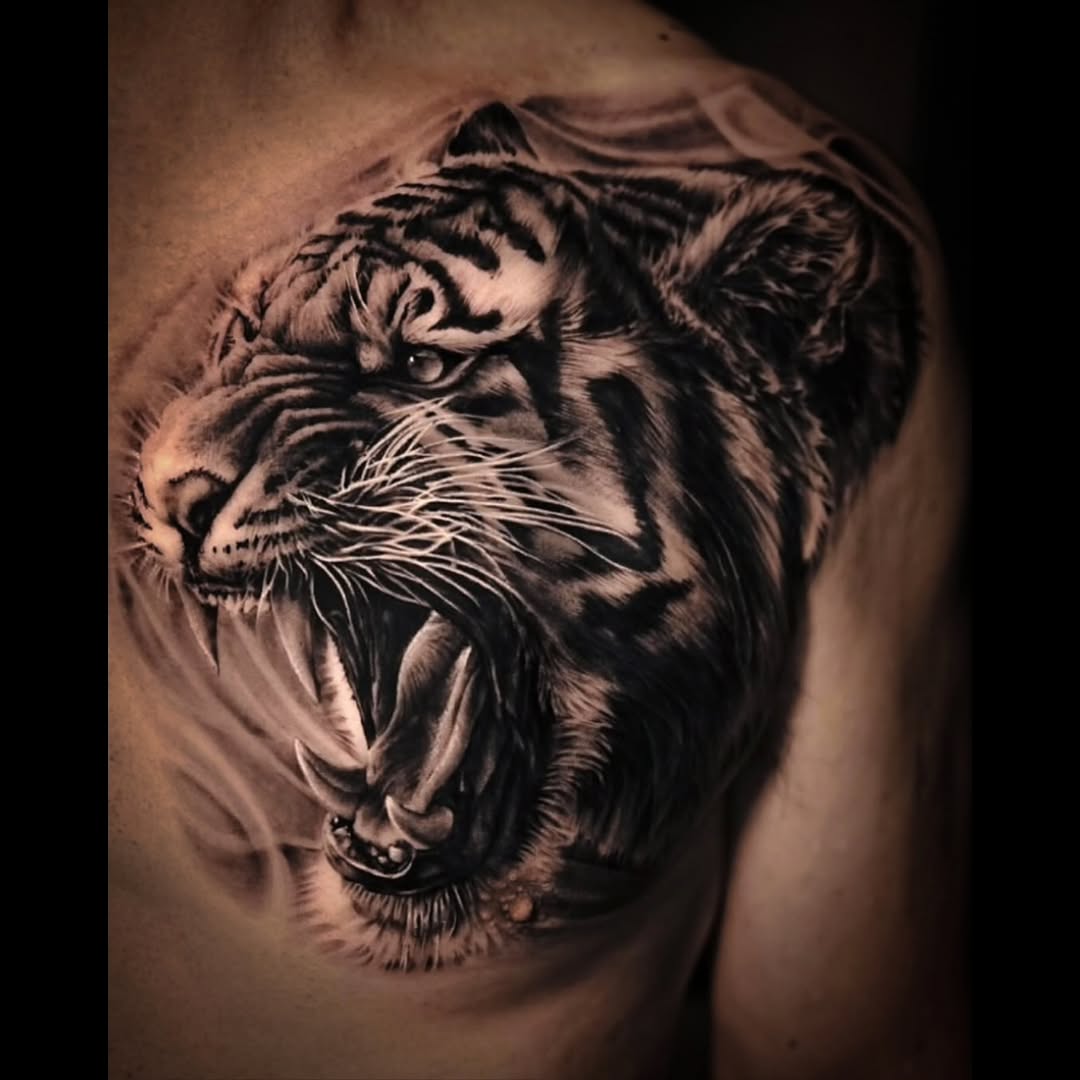 Roaring tiger head realism tattoo on the shoulder by Pitasso tattoo black and grey