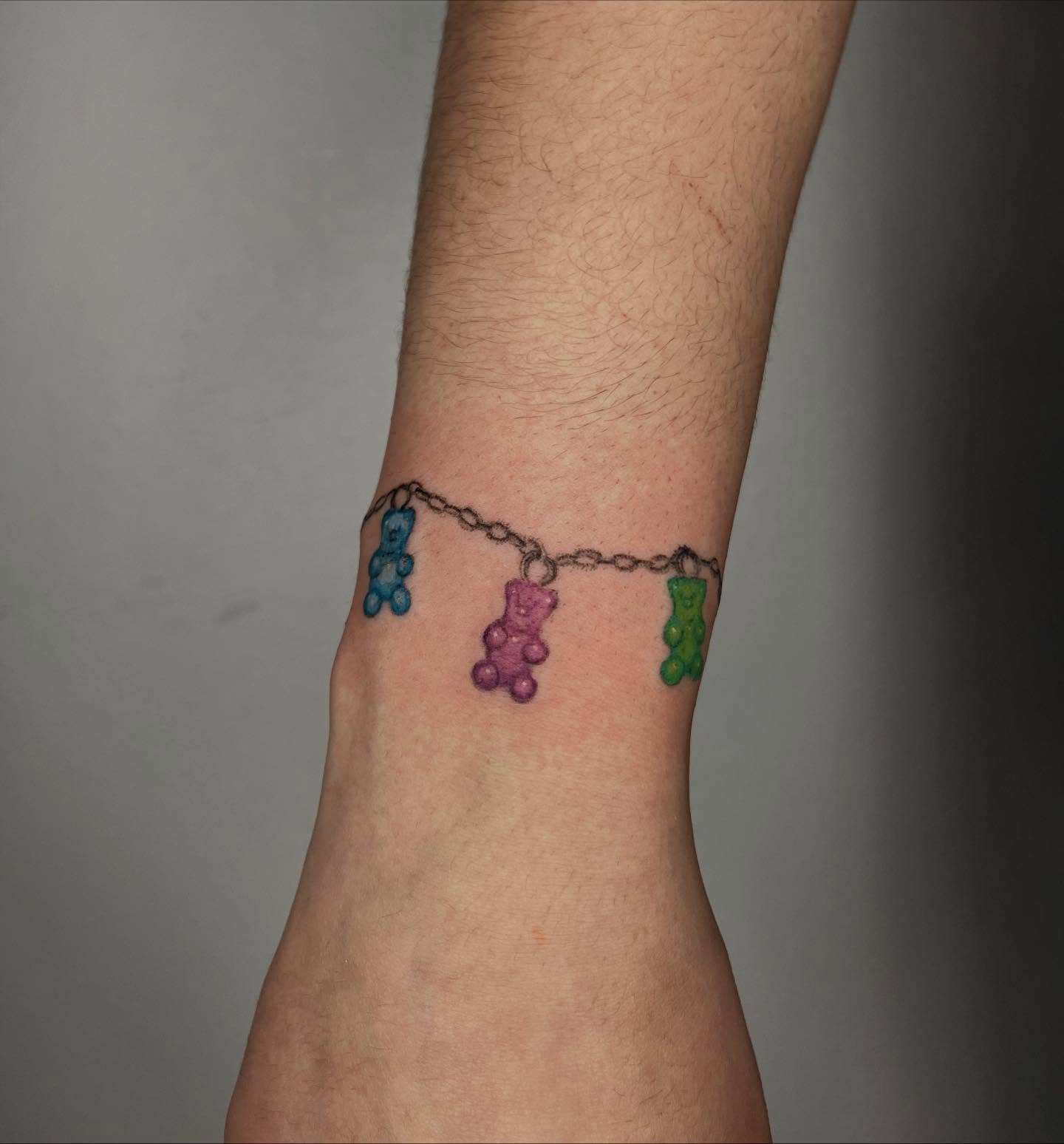 Gummy bear chain dotwork tattoo on the forearm by Gabbie