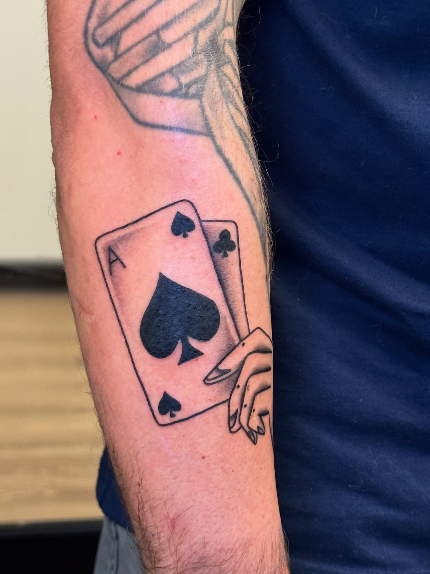 Playing cards black and grey tattoo on the forearm by Madison Pegram