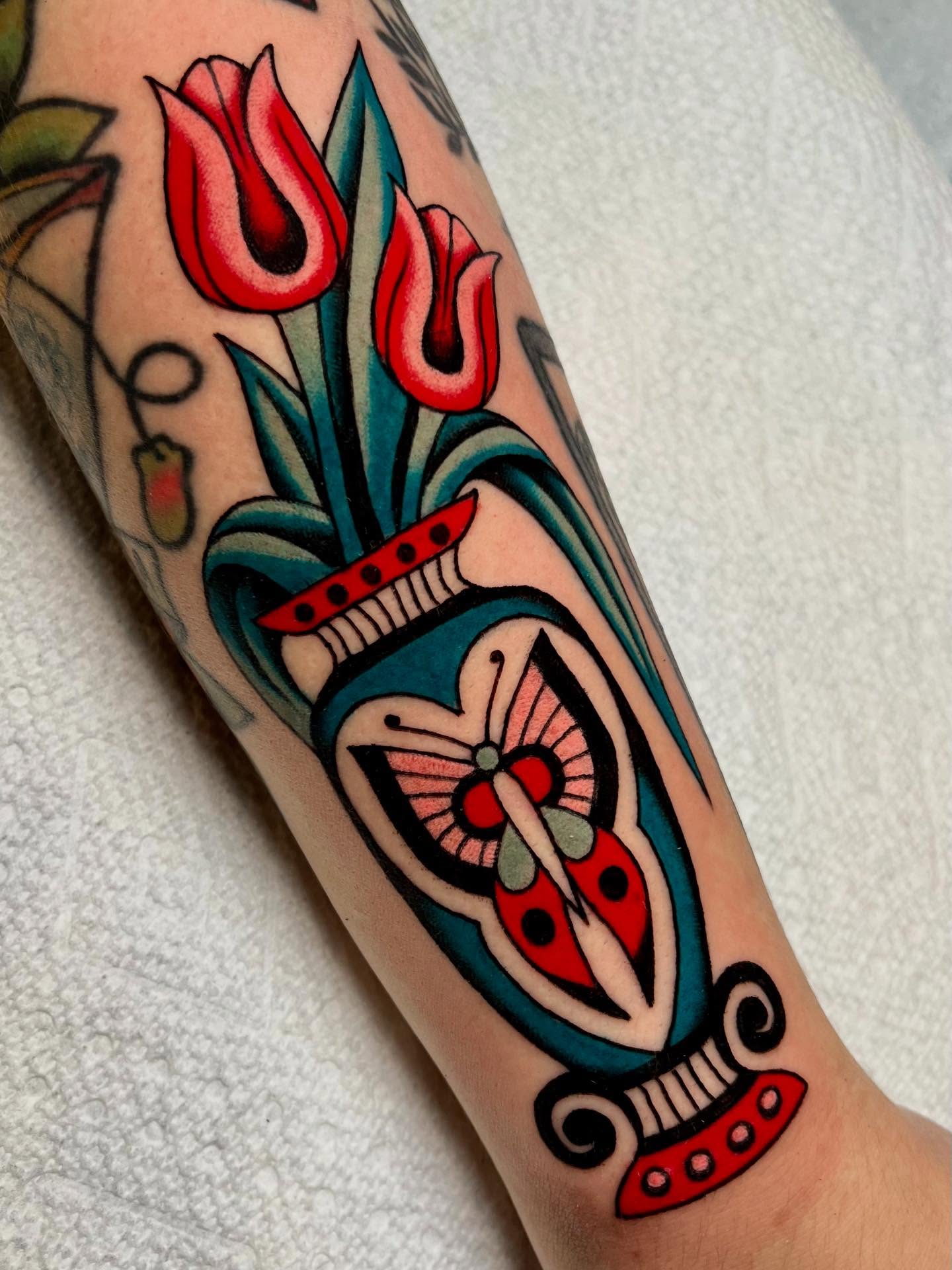Tulips and ladybug American traditional tattoo on the forearm by Liv :)