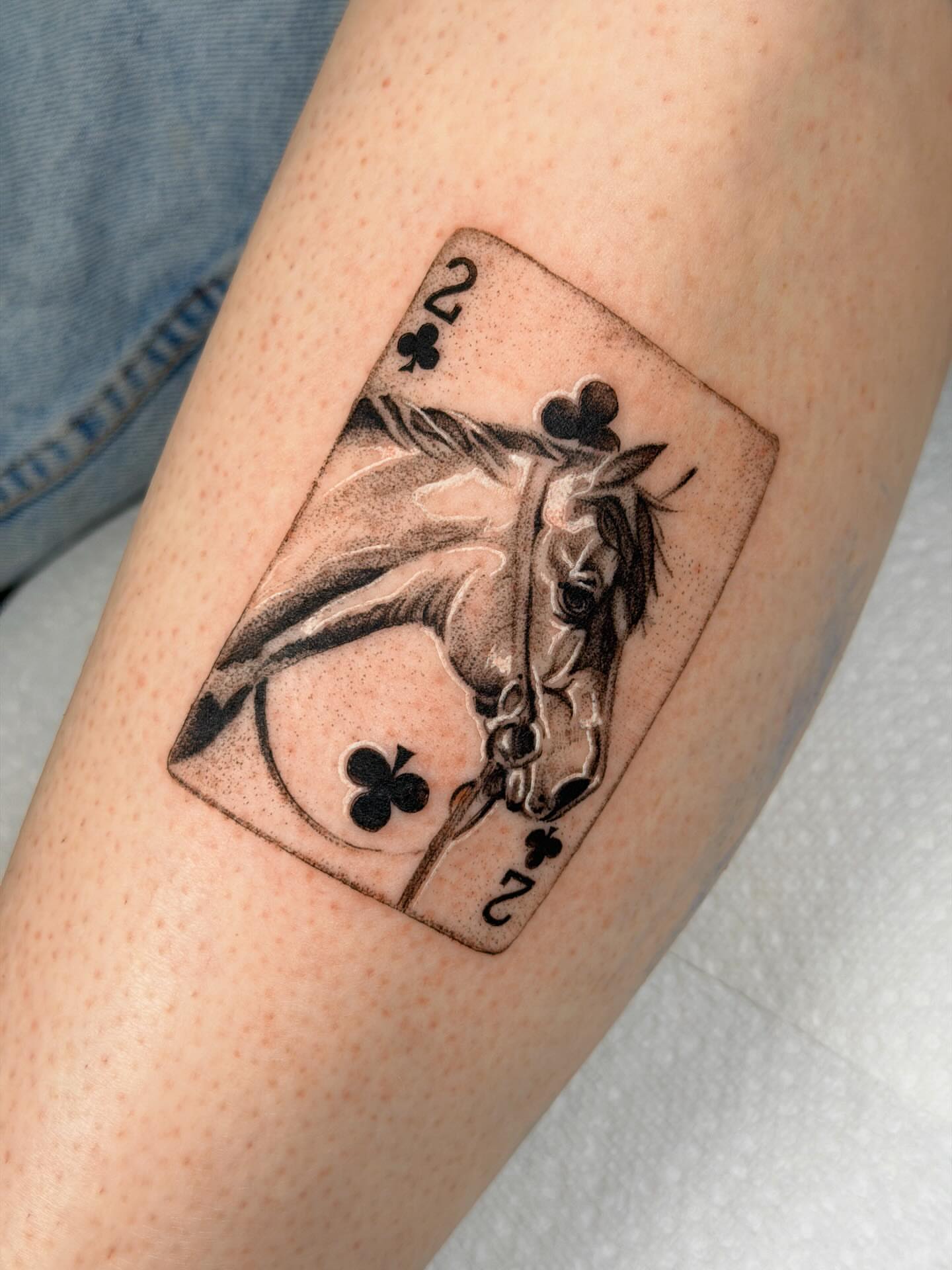 Playing card with horse realism tattoo on the forearm by Nate Weaver