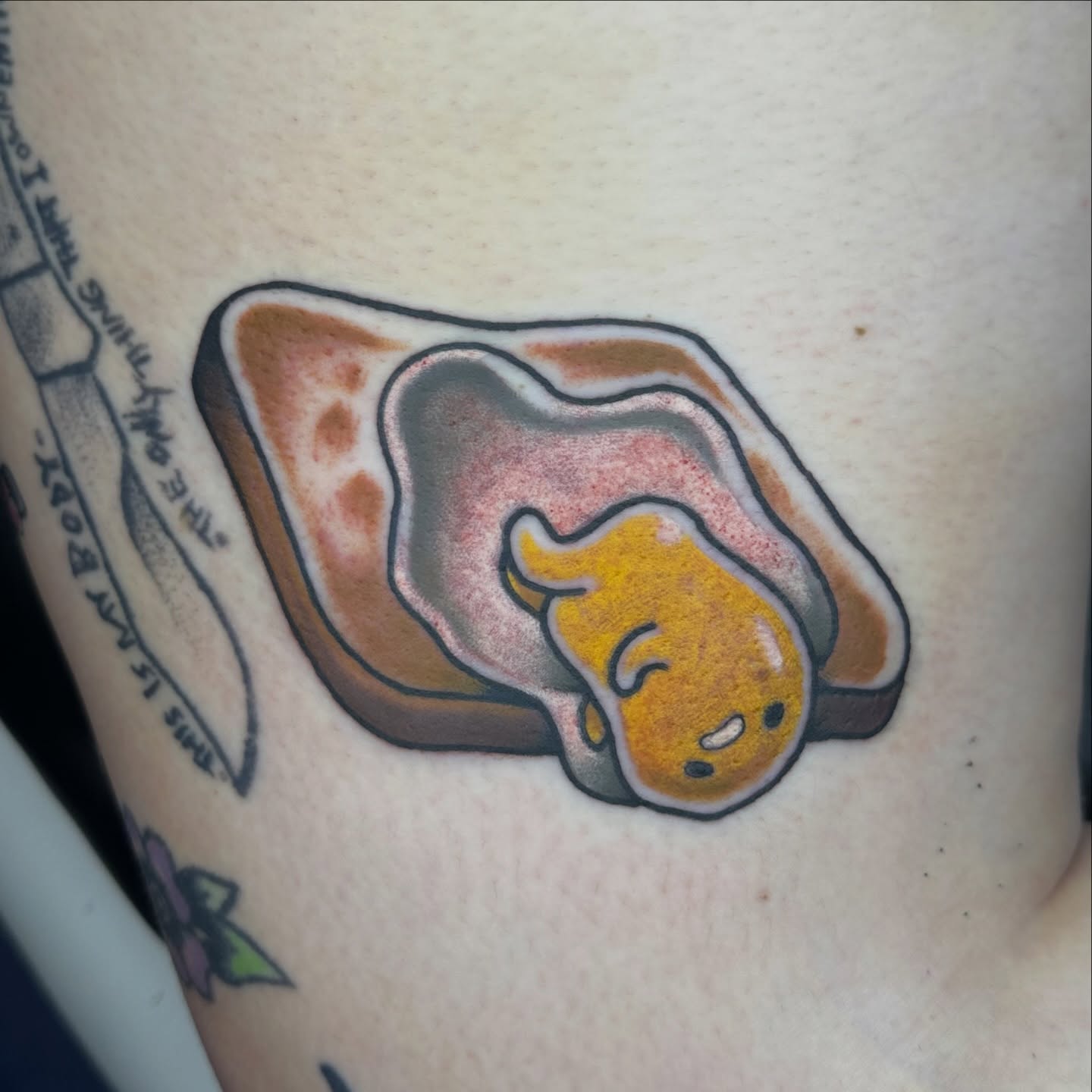 Toasted bread with gudetama new school tattoo on the upper arm by 🦷J.McHugh🦷