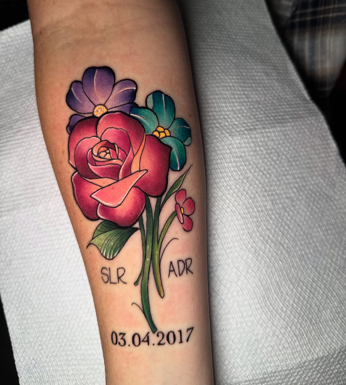 Flower bouquet realism tattoo on the forearm by Caitlyn