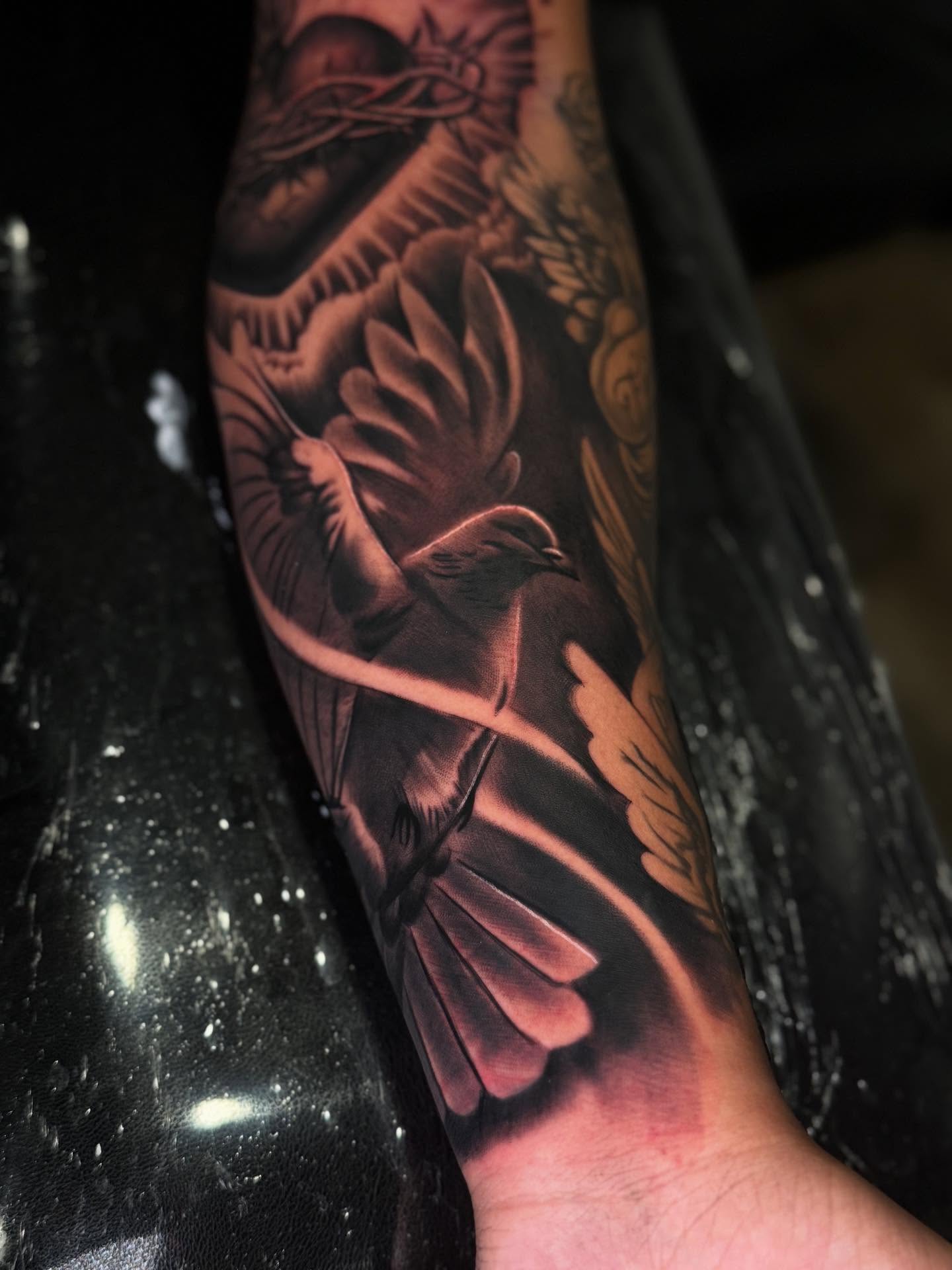 Bird and floral realism tattoo on the forearm by Jose Mendoza Torres