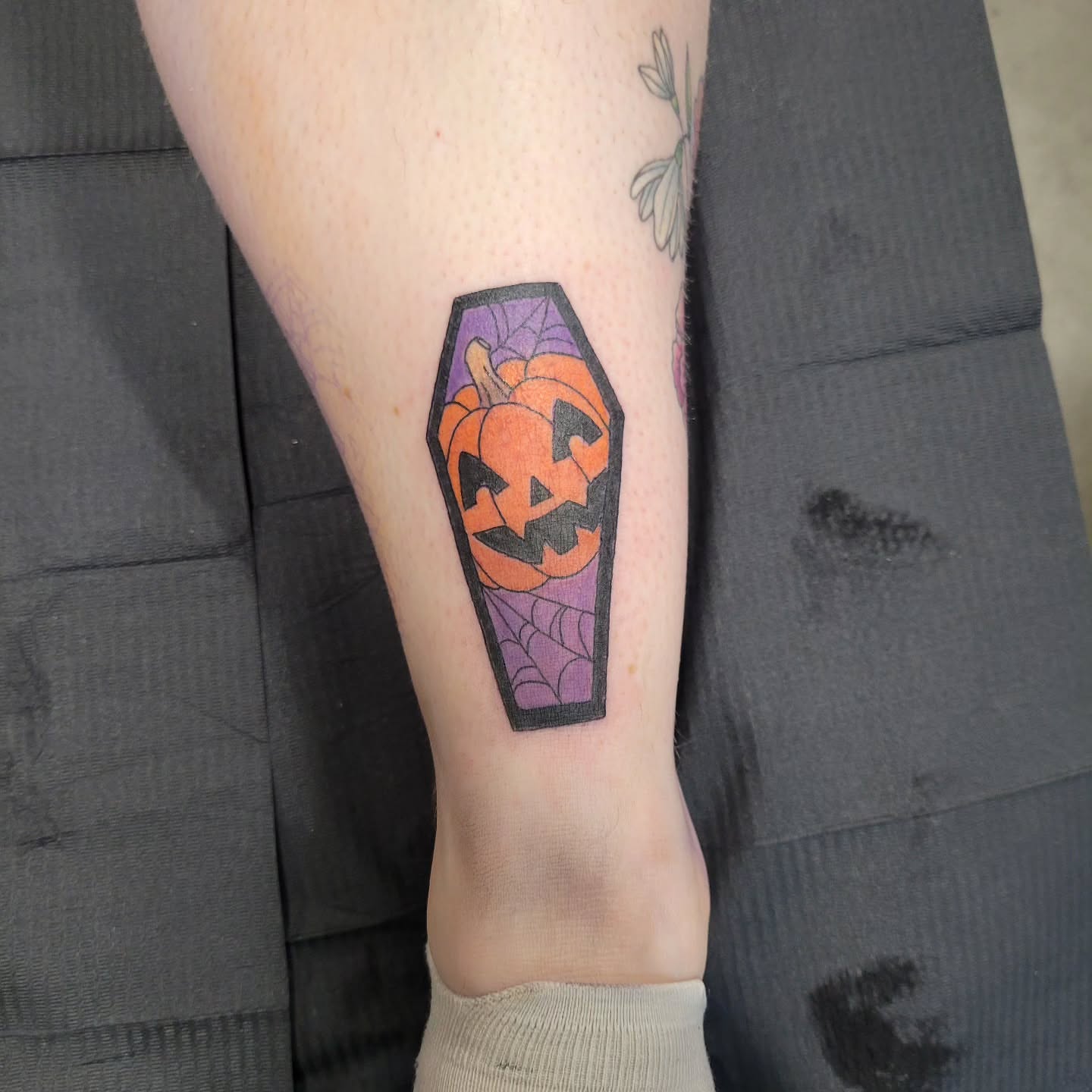 Pumpkin in coffin American traditional tattoo on the calf by Aspen C
