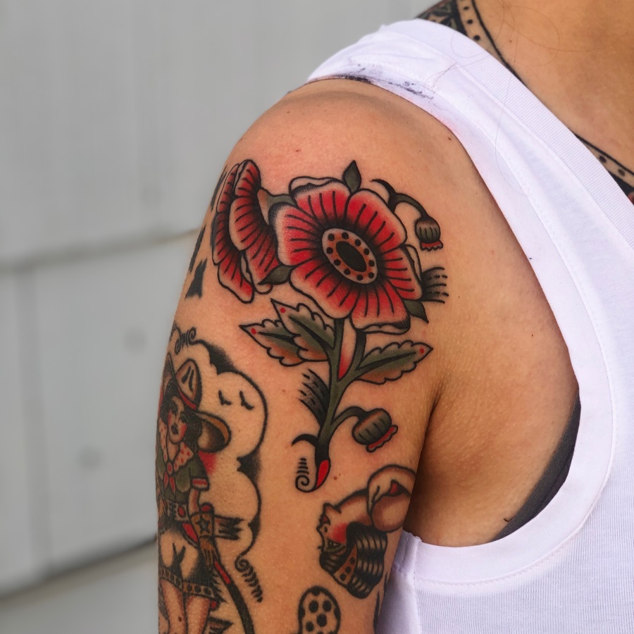 Red poppy American traditional tattoo on the shoulder by EVA Traditional Tattoos
