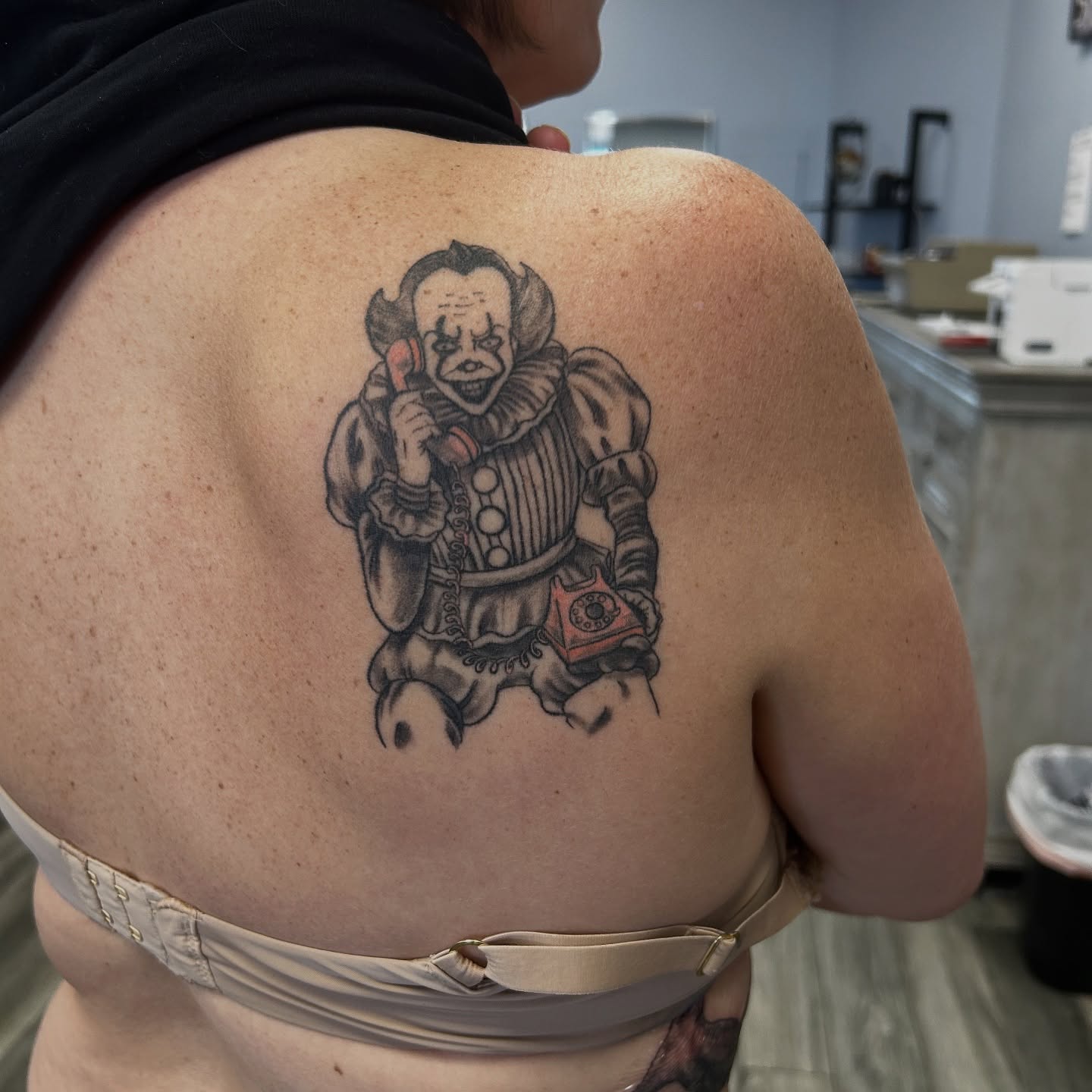 Clown with telephone black and grey tattoo on the back by Brittany Brutal