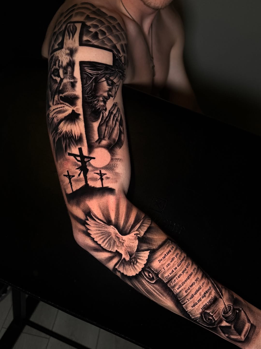 Lion, Jesus, crosses, dove, and scripture realism tattoo on the forearm by Henry Fuentes