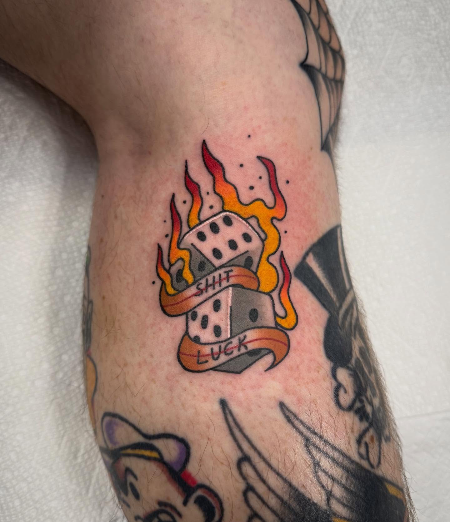 Flaming dice American traditional tattoo on the forearm by Abby Hofman