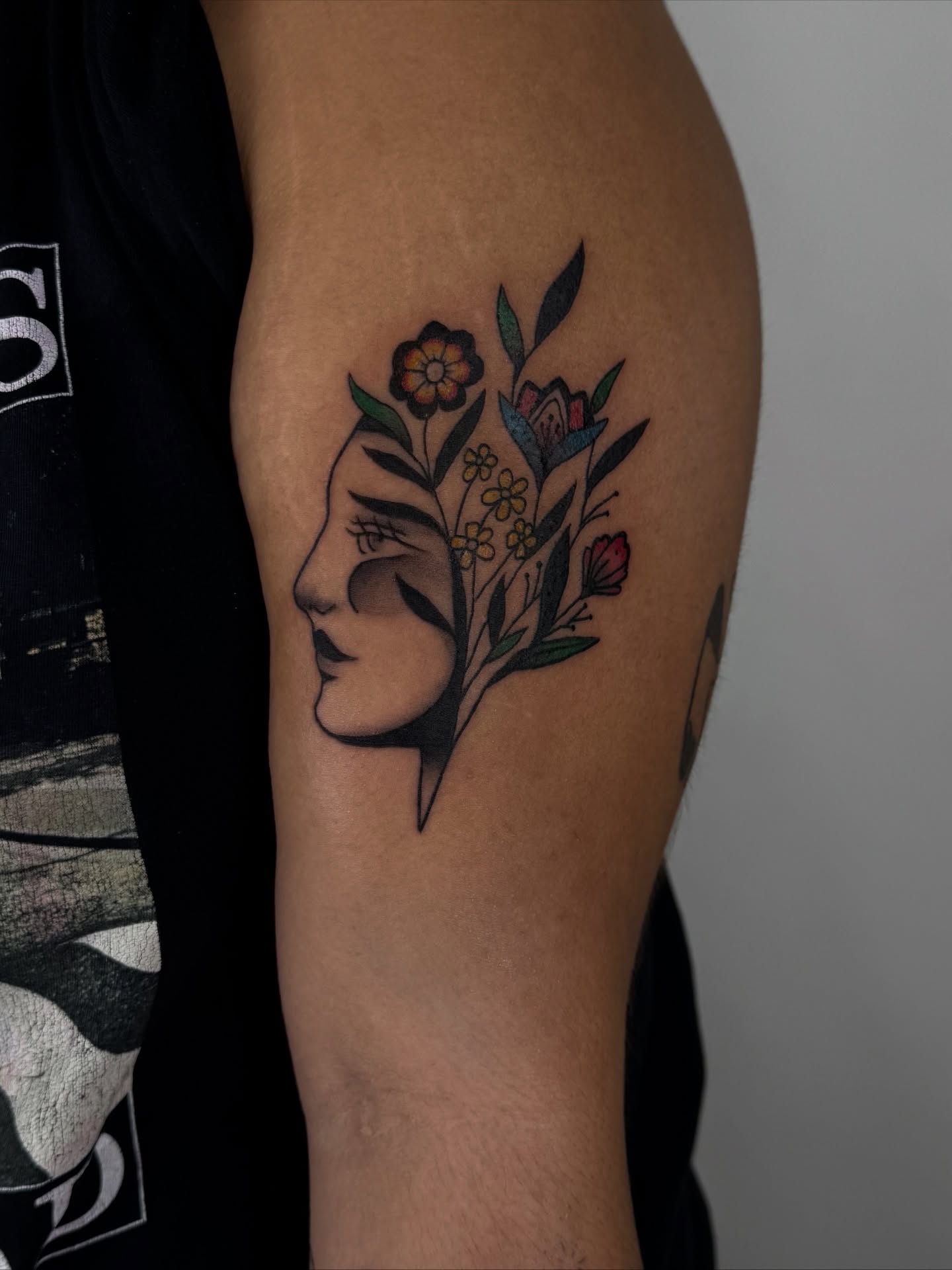 Floral profile neo-traditional tattoo on the upper arm by sabina
