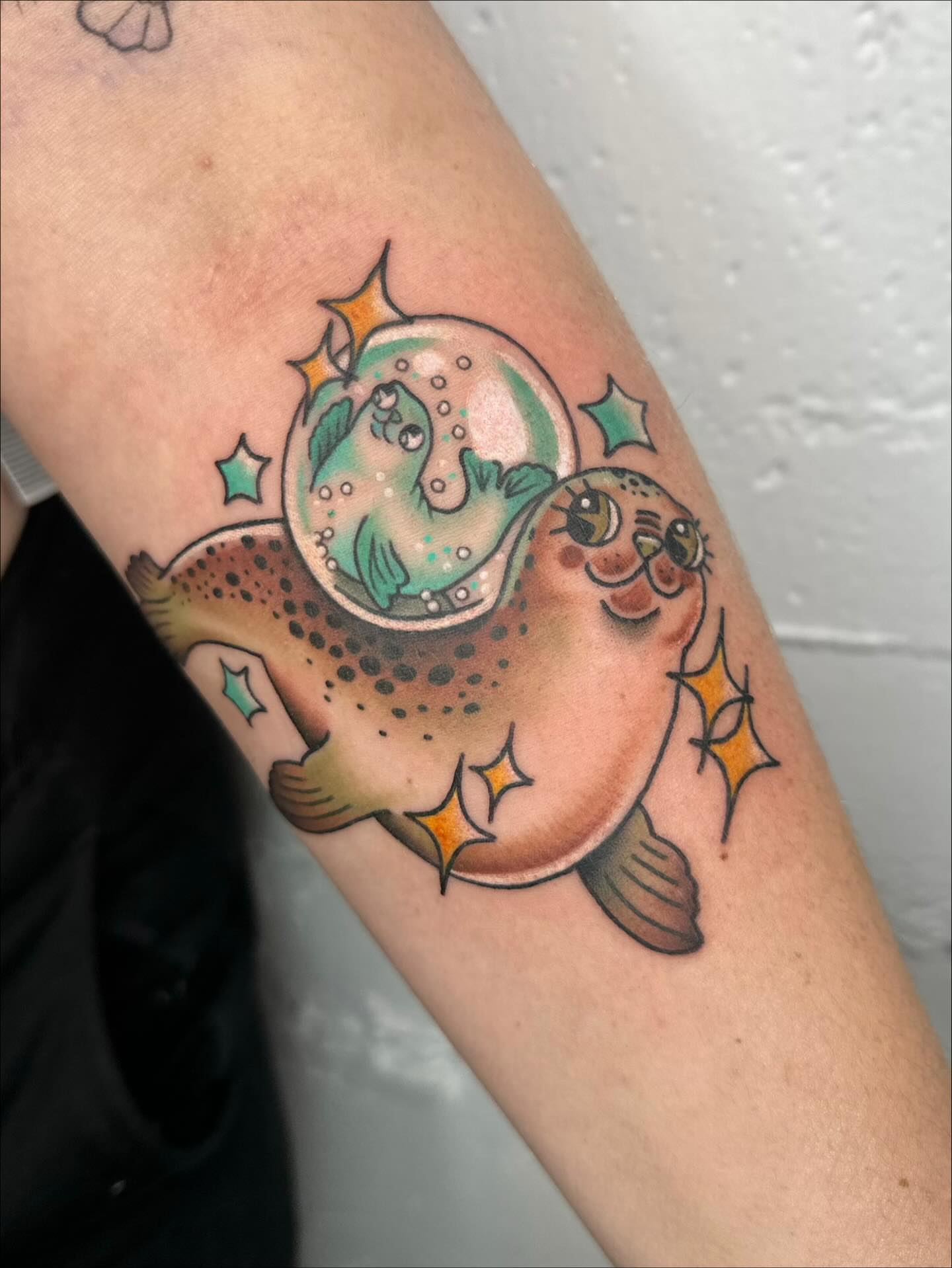 Sea otter and pufferfish new school tattoo on the forearm by mia palau