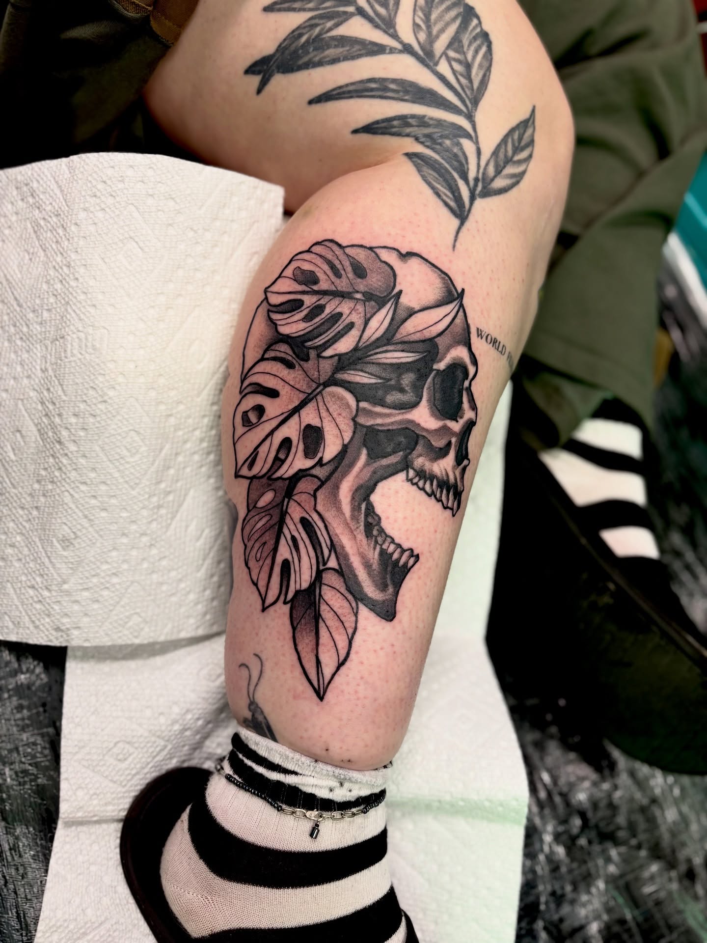 Skull with leaves realism tattoo on the forearm by Ogden Tattoo Parlor