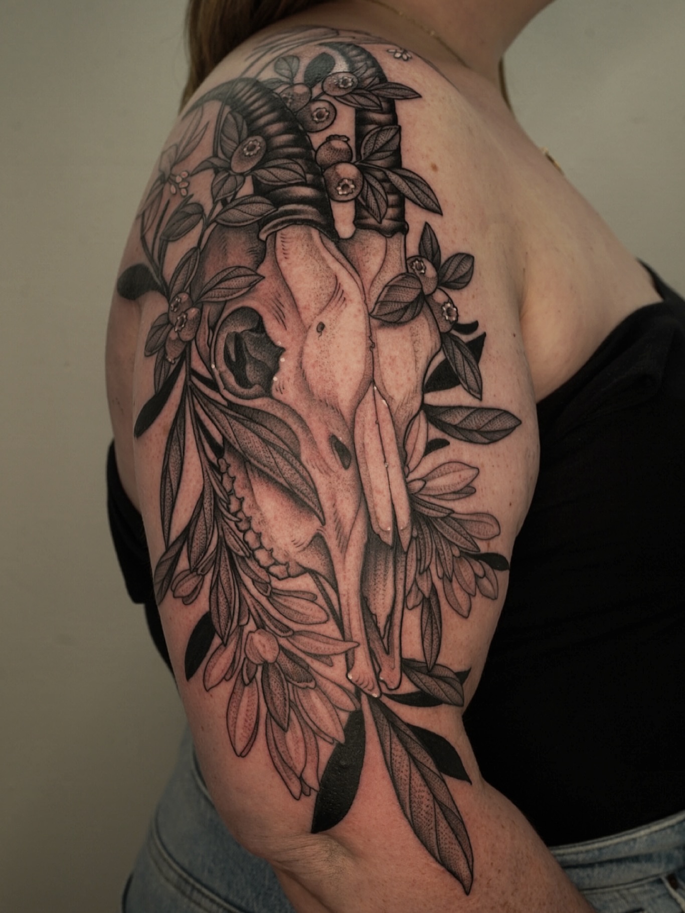 Skull and floral realism tattoo on the shoulder by Kyle Stacher - Blackwork Tattoos - Denver