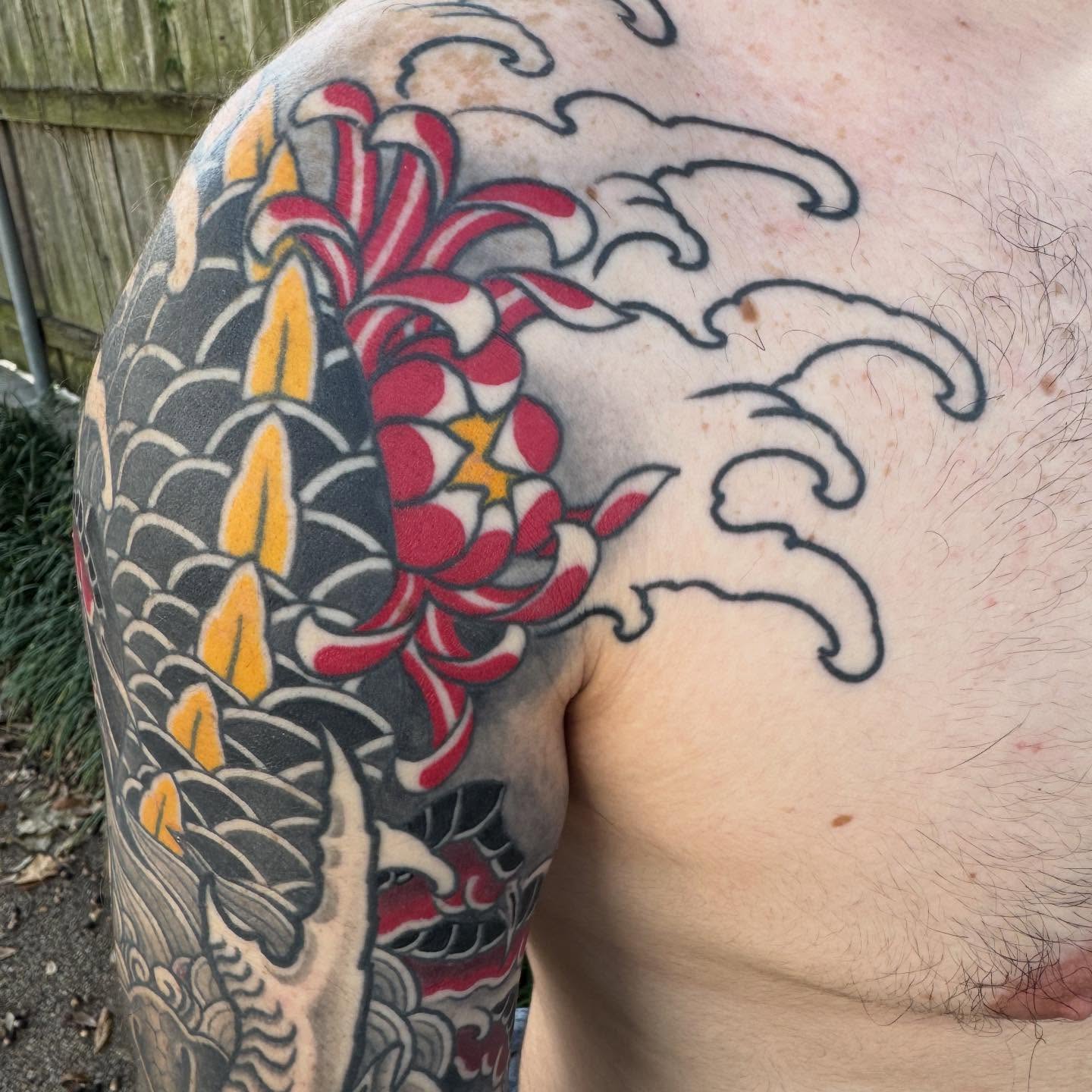 Koi fish and chrysanthemum American traditional tattoo on the shoulder by Jeremy Justice, New Orleans, Louisiana
