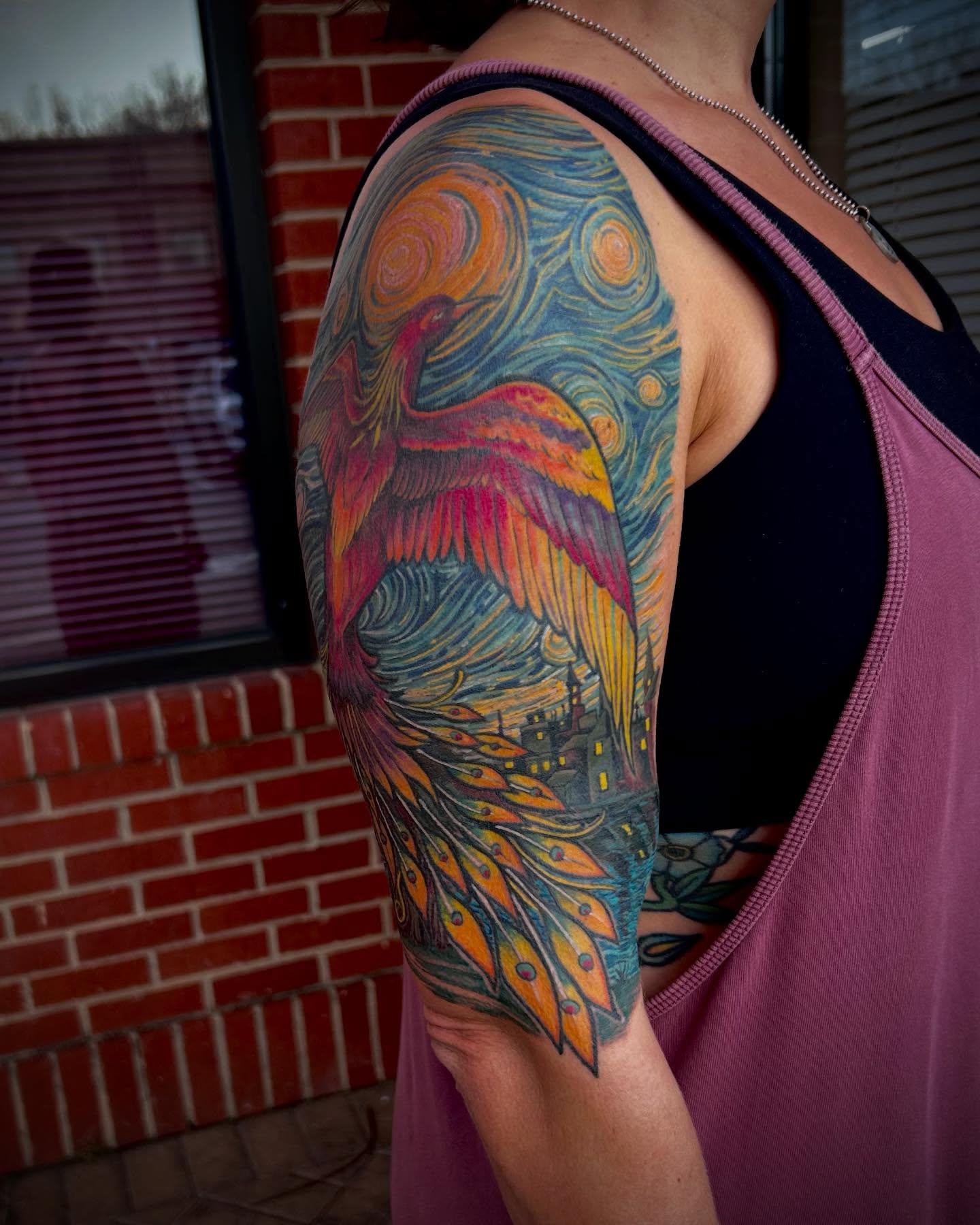 Peacock new school tattoo on the upper arm by Jon Byrd