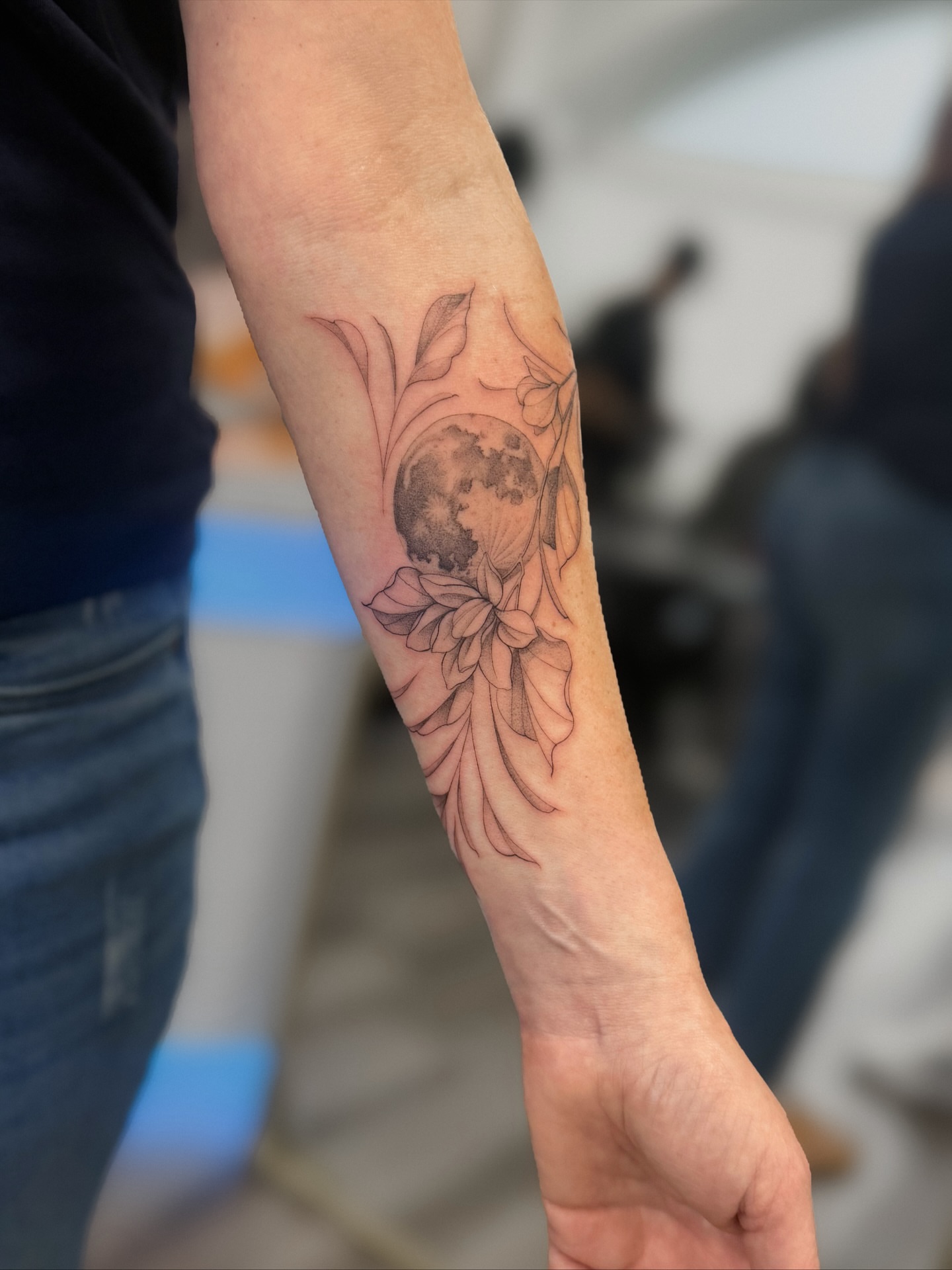 Moon and floral black and grey tattoo on the forearm by Daniel Montoya, Charlotte, North Carolina