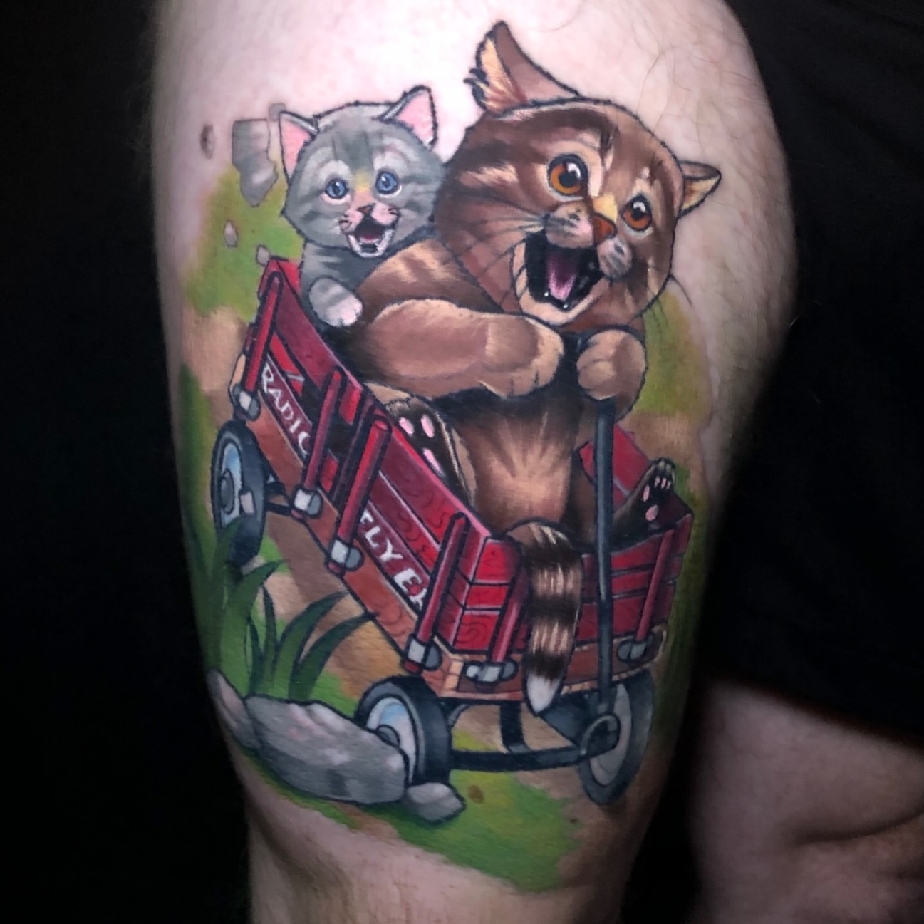 Cat pulling wagon realism tattoo on the thigh by Emily Walker