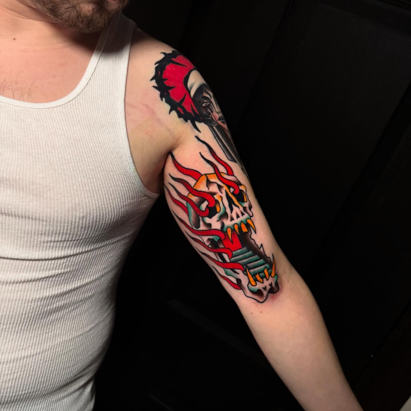 Skull with flames American traditional tattoo on the forearm by Nate Masi