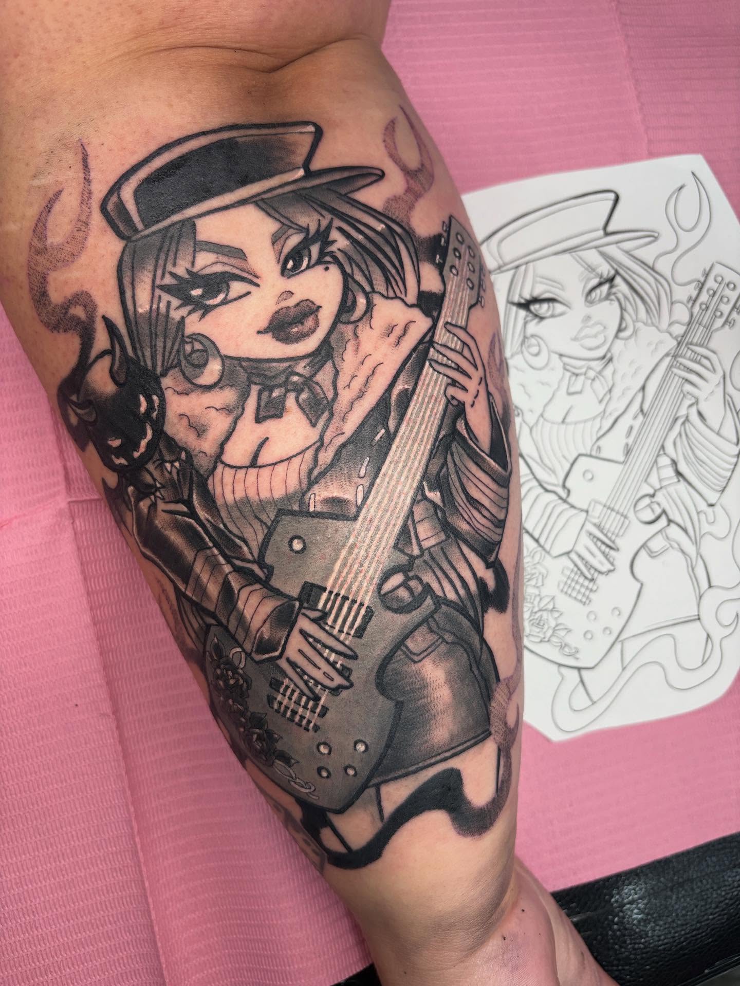 Guitar-playing woman realism tattoo on the forearm by Gabby