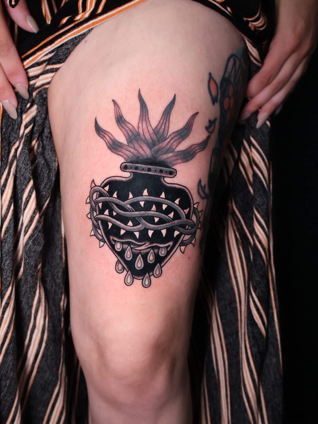 Heart with flames black and grey tattoo on the thigh by Brandon Bear