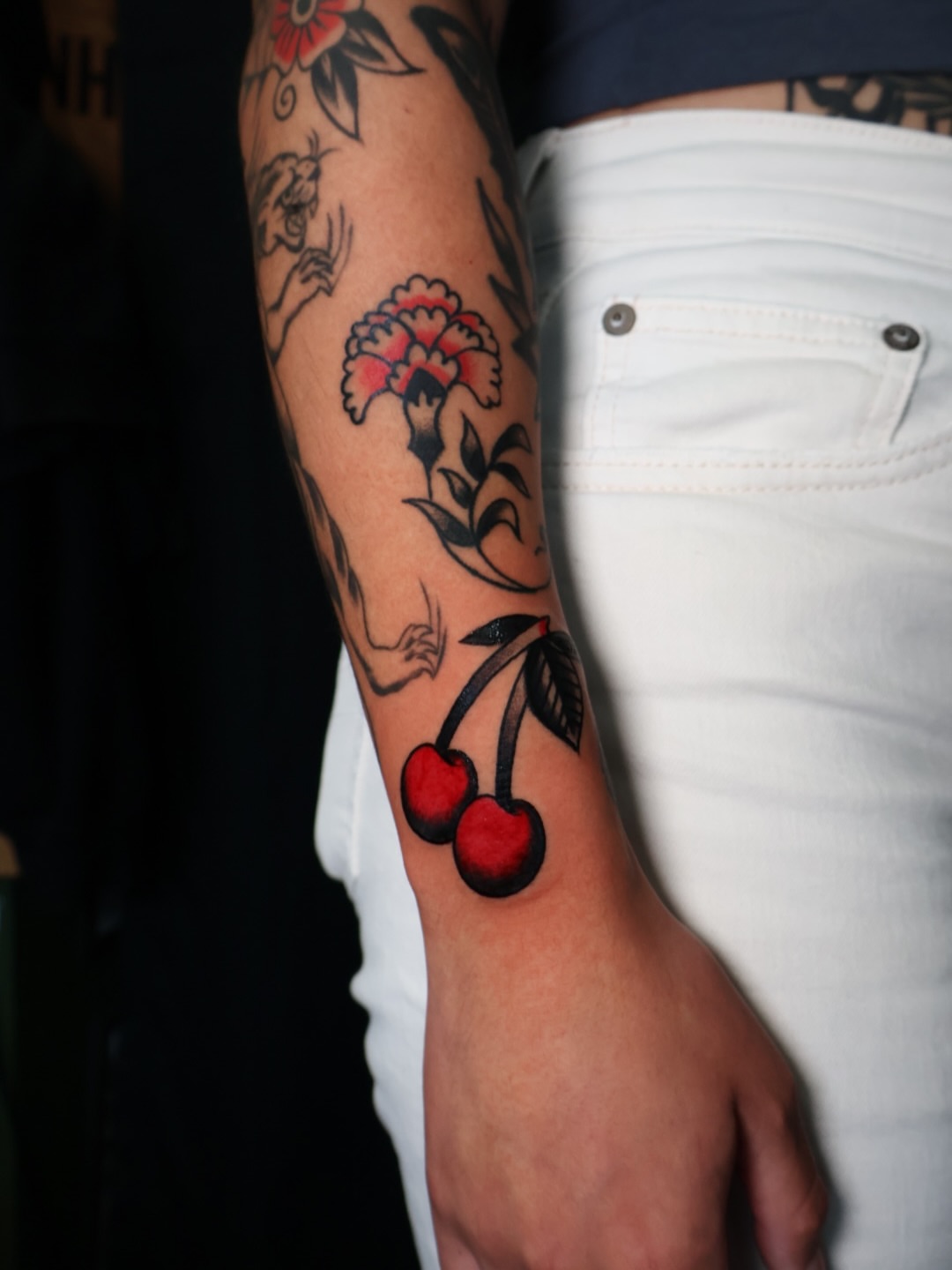 Cherry and flower American traditional tattoo on the forearm by Brandon Bear