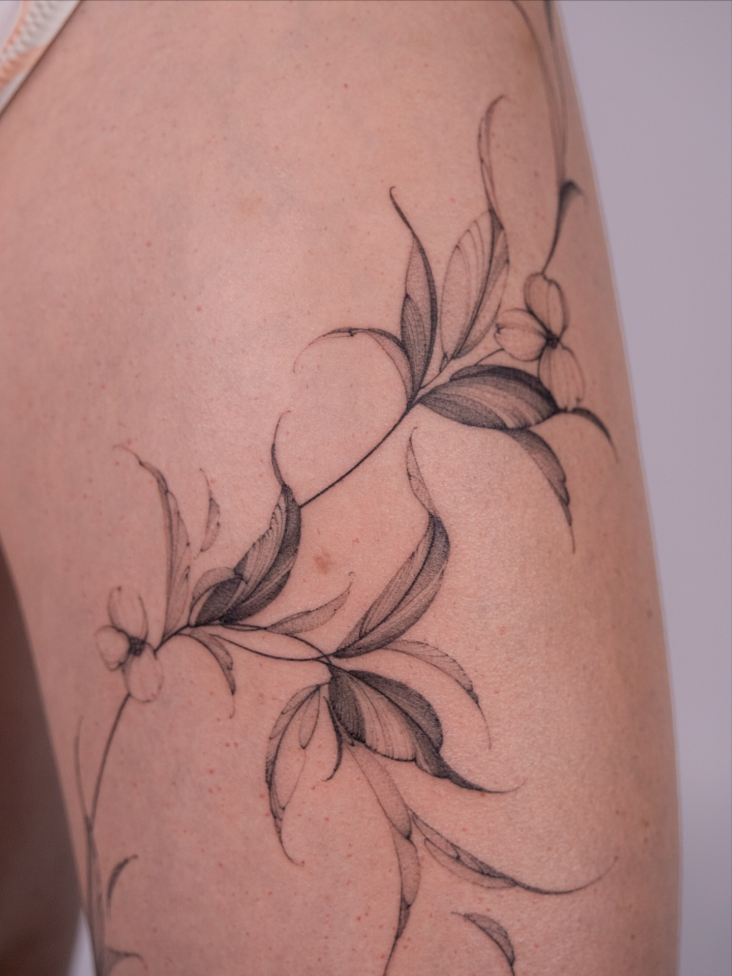 Floral vine black and grey tattoo on the thigh by i flower you
