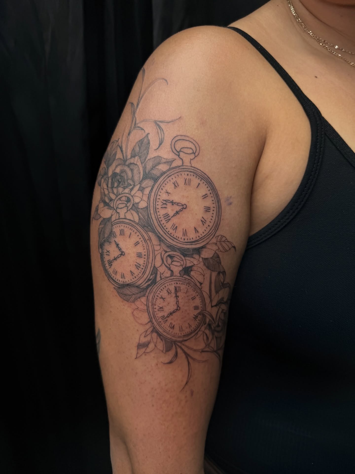 Clocks and flowers realism tattoo on the upper arm by Elijah Cosme, Miami, Florida