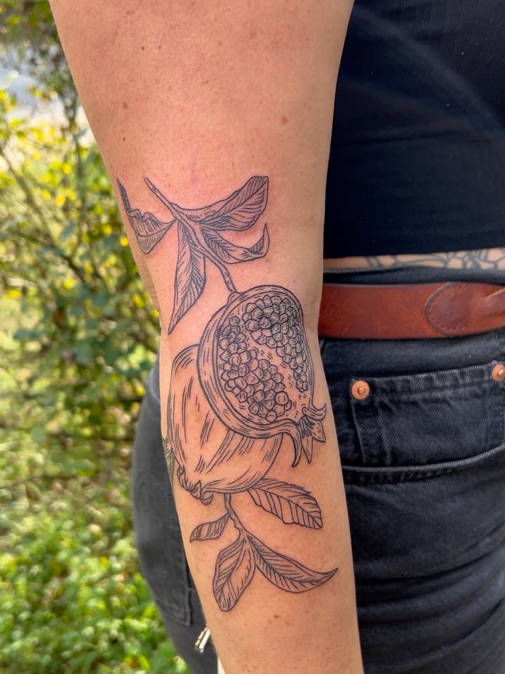 Pomegranate black and grey tattoo on the forearm by Rose DeLisse