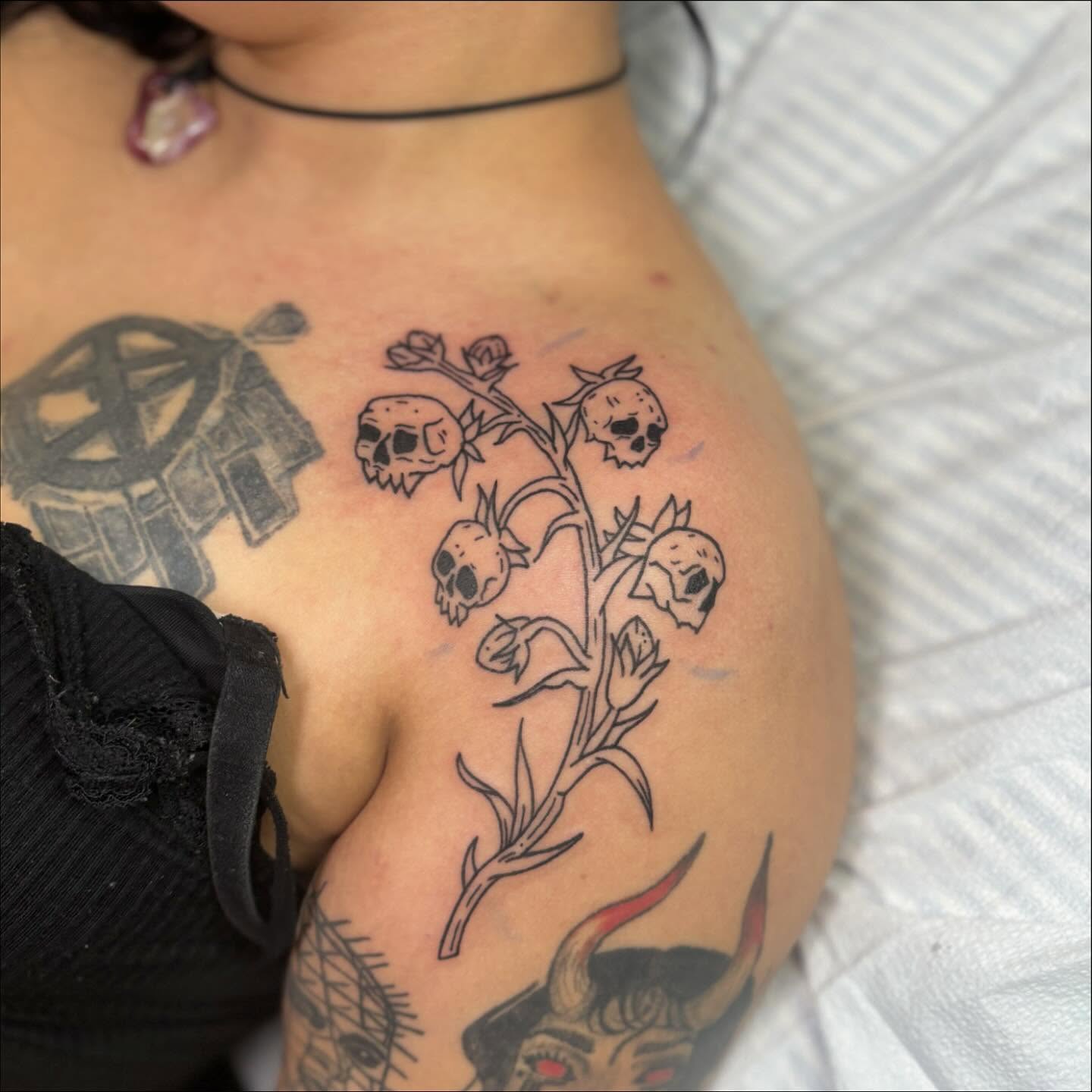 Skull flowers black and grey tattoo on the shoulder by Cam Sykes