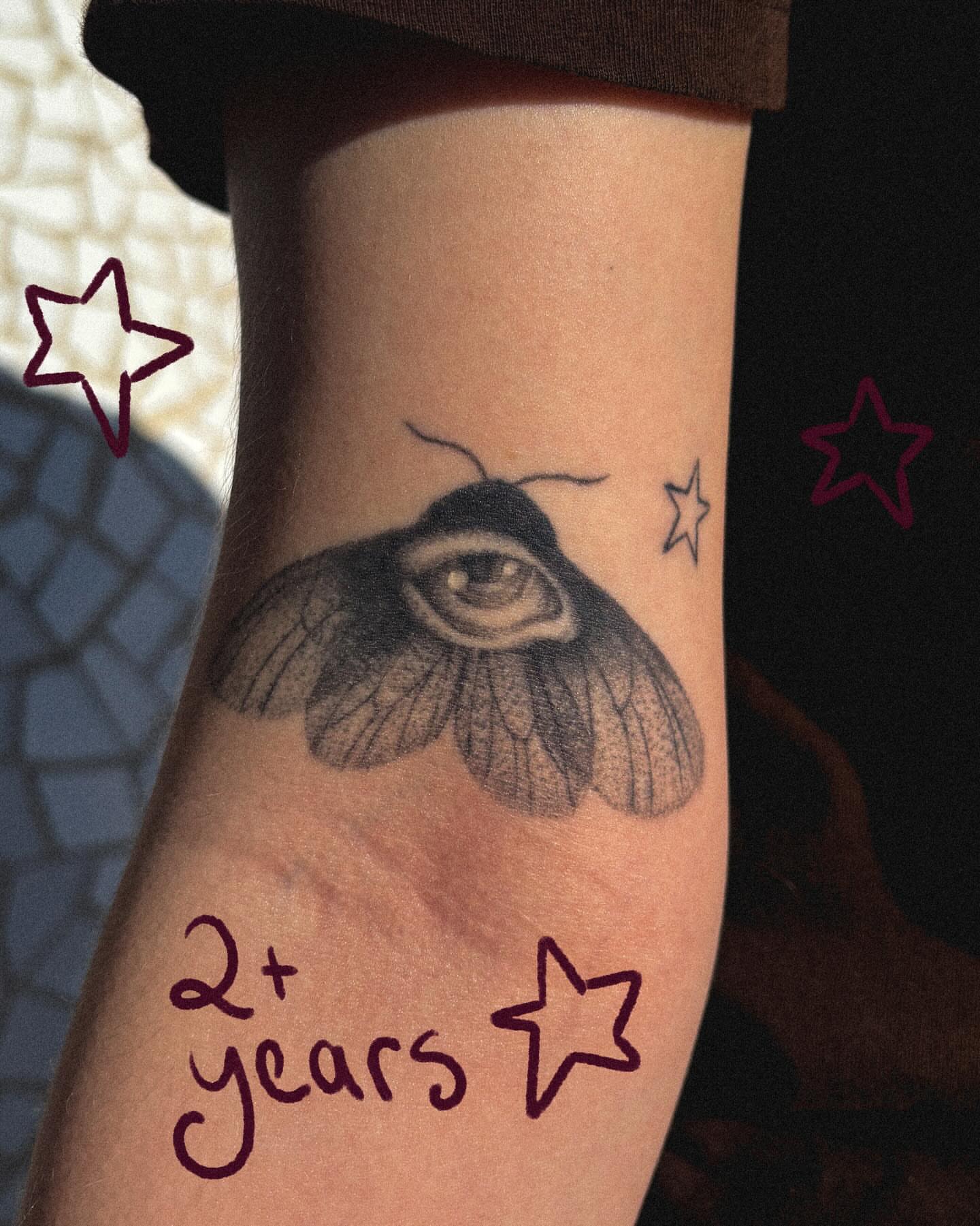 Moth with eye black and grey tattoo on the forearm by Autumn