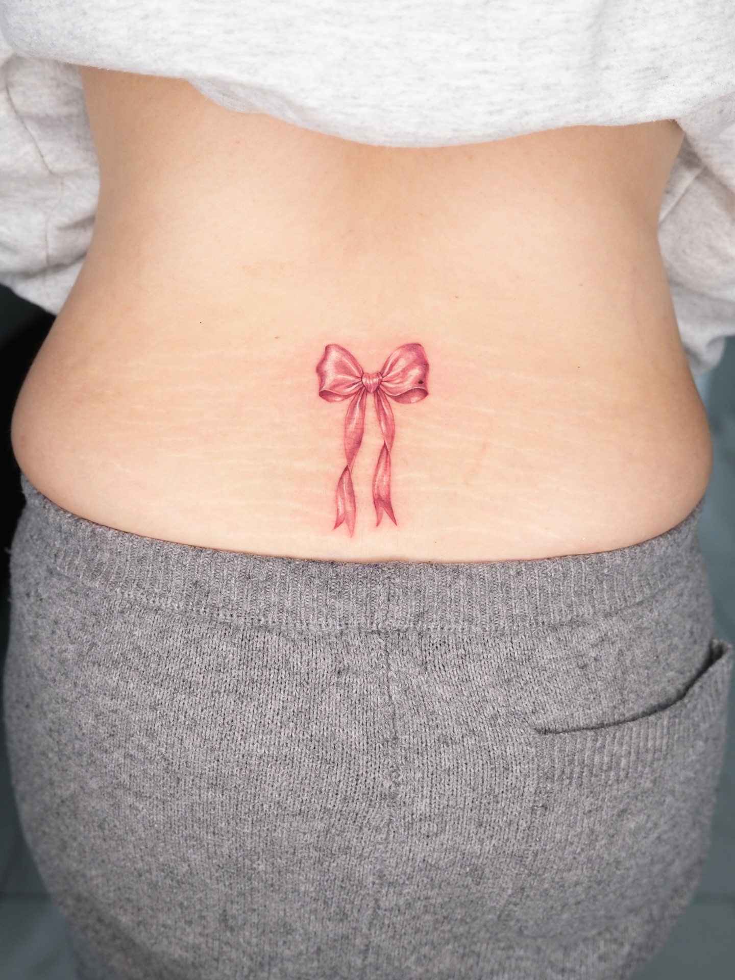 Bow realism tattoo on the torso by Bay Area Tattoo Artist
