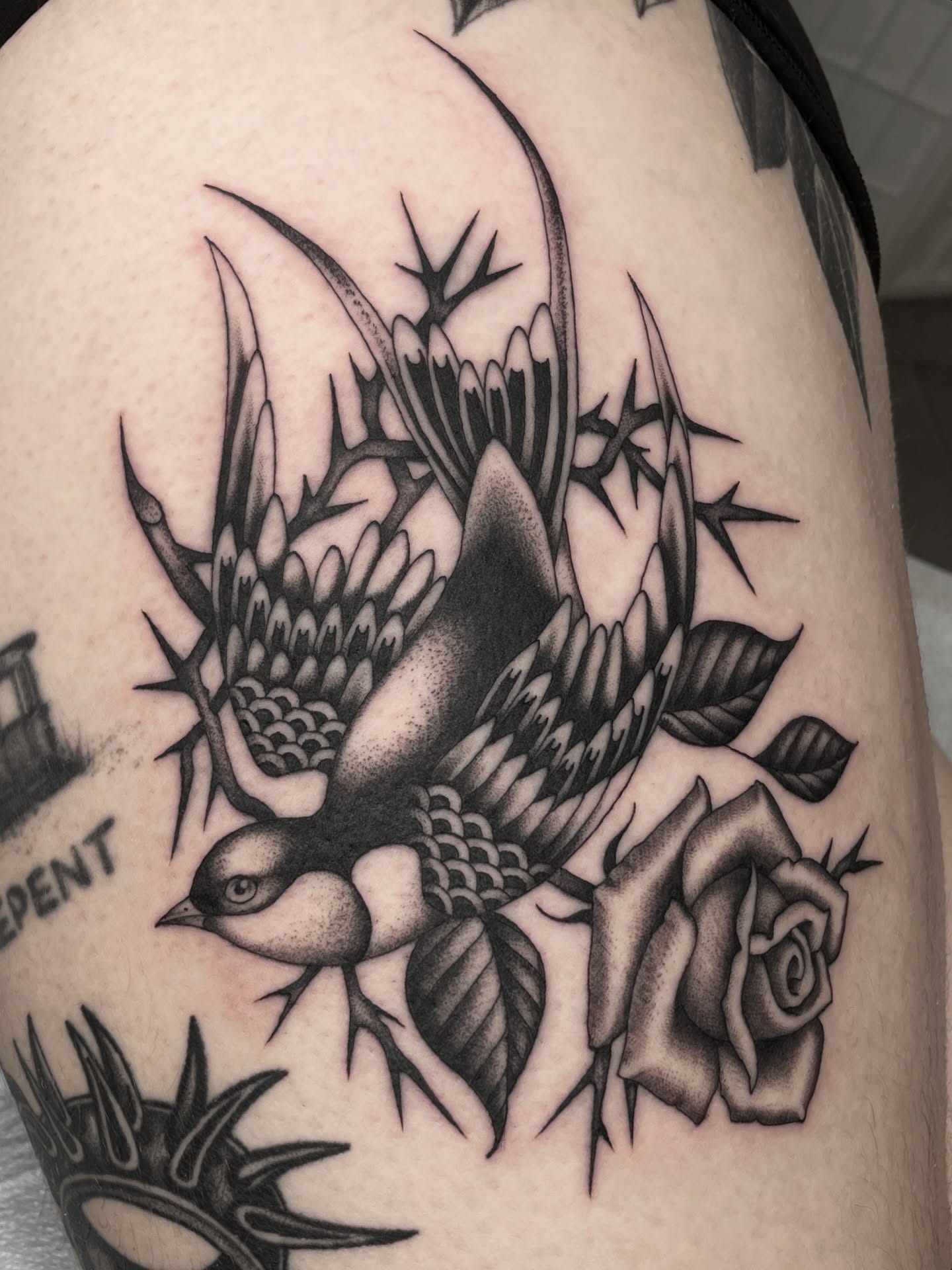 Bird and thistle American traditional tattoo on the thigh by Dakota Jenner