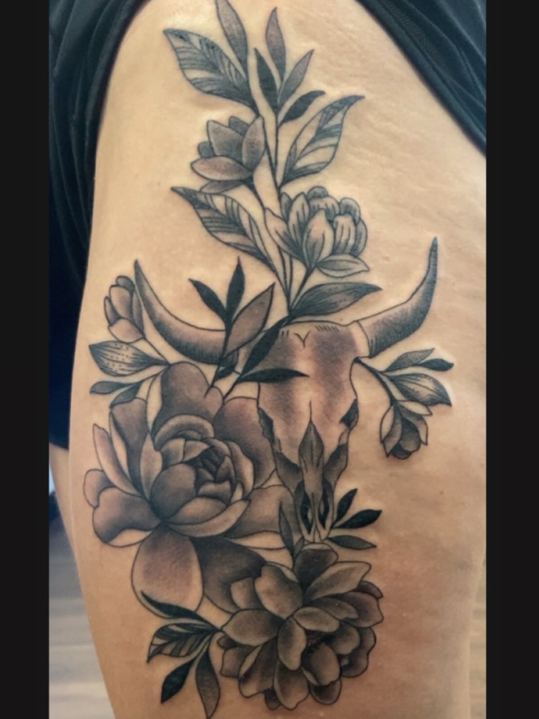 Cow skull and flowers black and grey tattoo on the shoulder by Erin McGloin