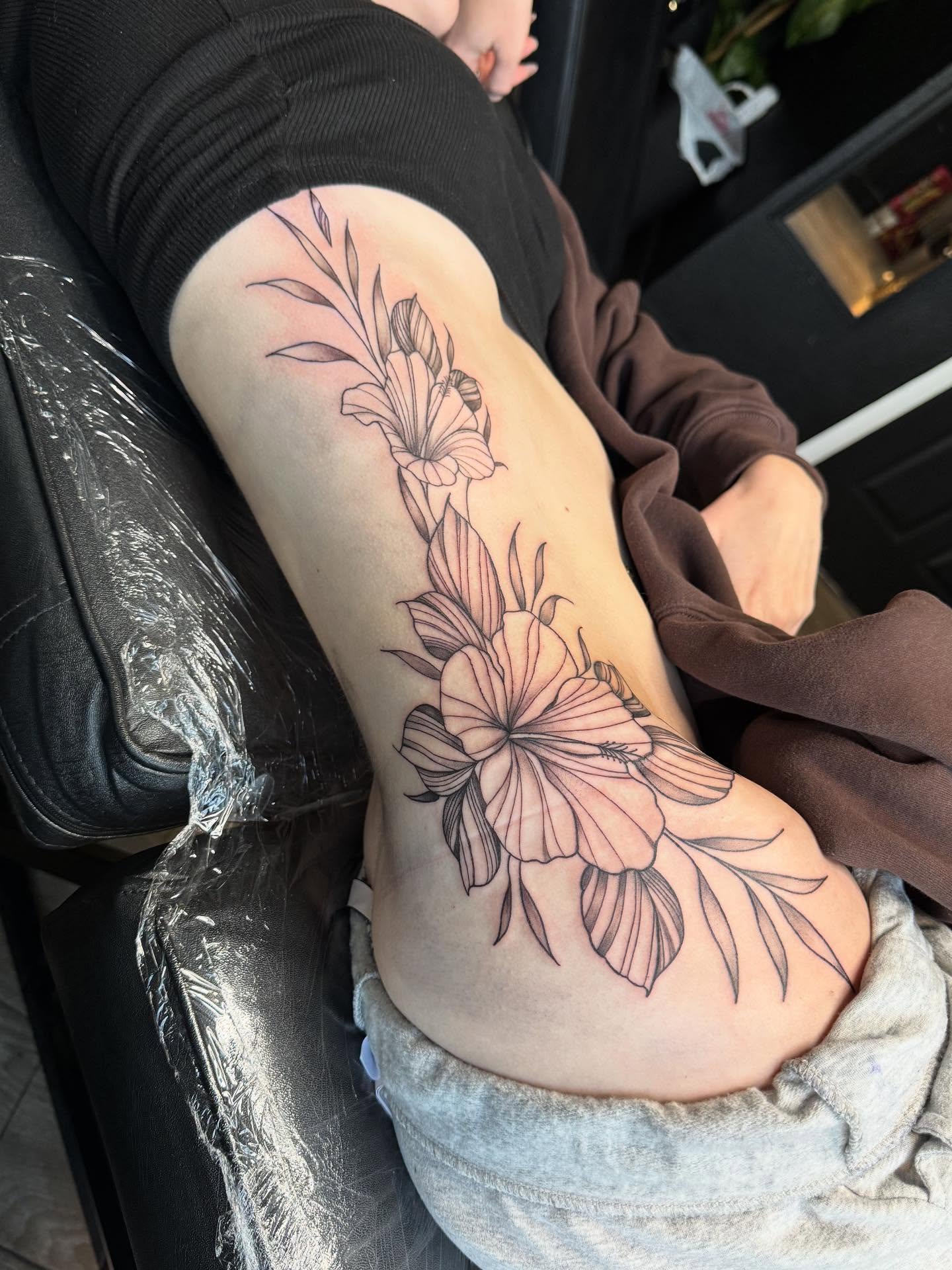 Floral arrangement black and grey tattoo on the thigh by Mickey
