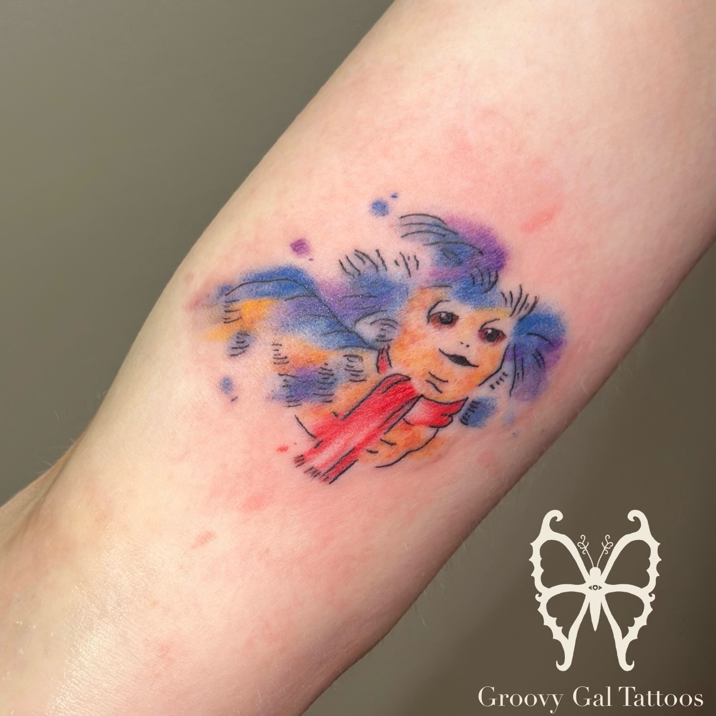 Child with butterfly wings watercolor tattoo on the forearm by Groovy P